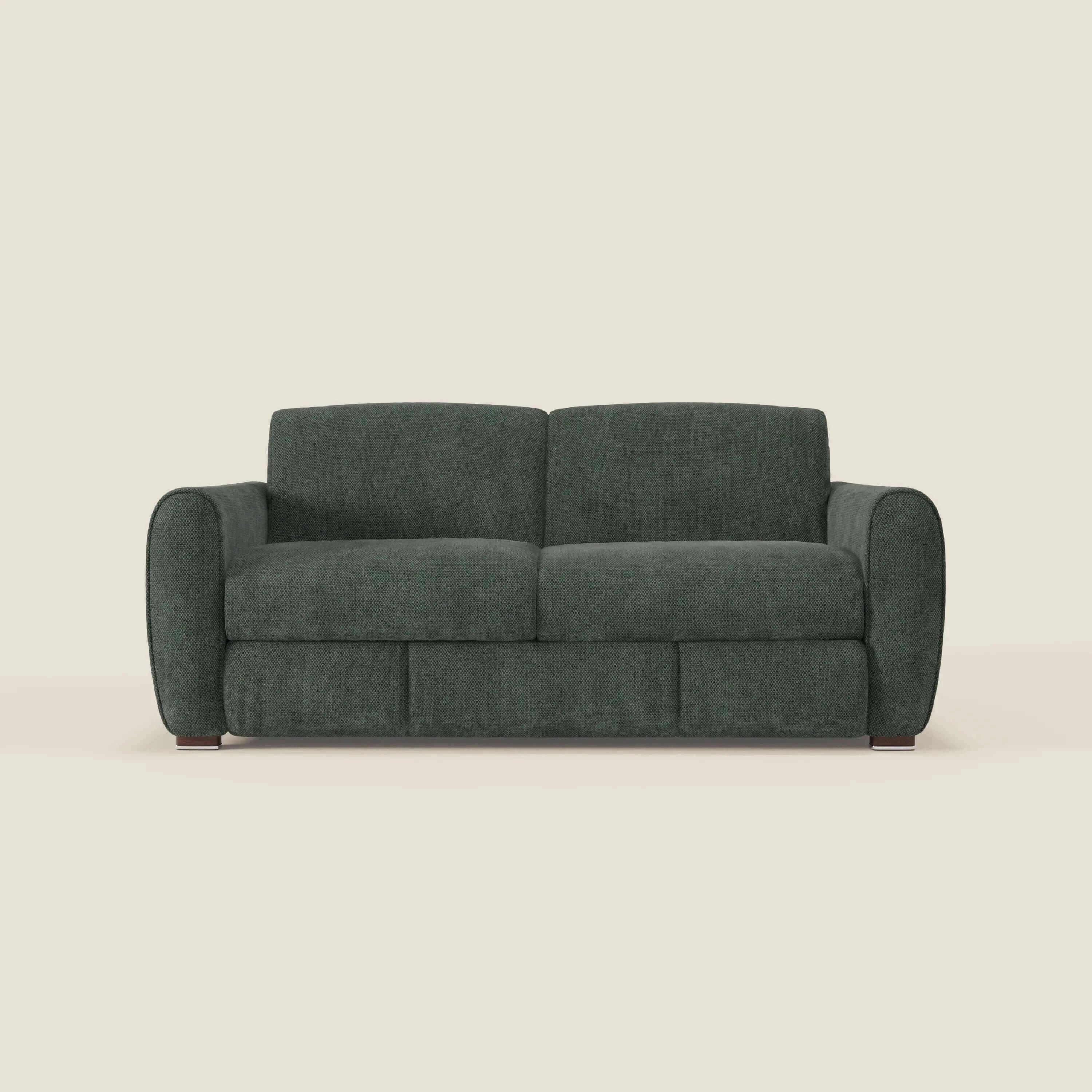 Il divano letto moderno Kaleo di Divani.Store, in tessuto impermeabile T26 verde oliva, è caratterizzato da braccioli arrotondati, cuscini in feltro, seduta e schienale in materasso H17 cm ad alta densità e gambe corte in legno su sfondo bianco sporco.