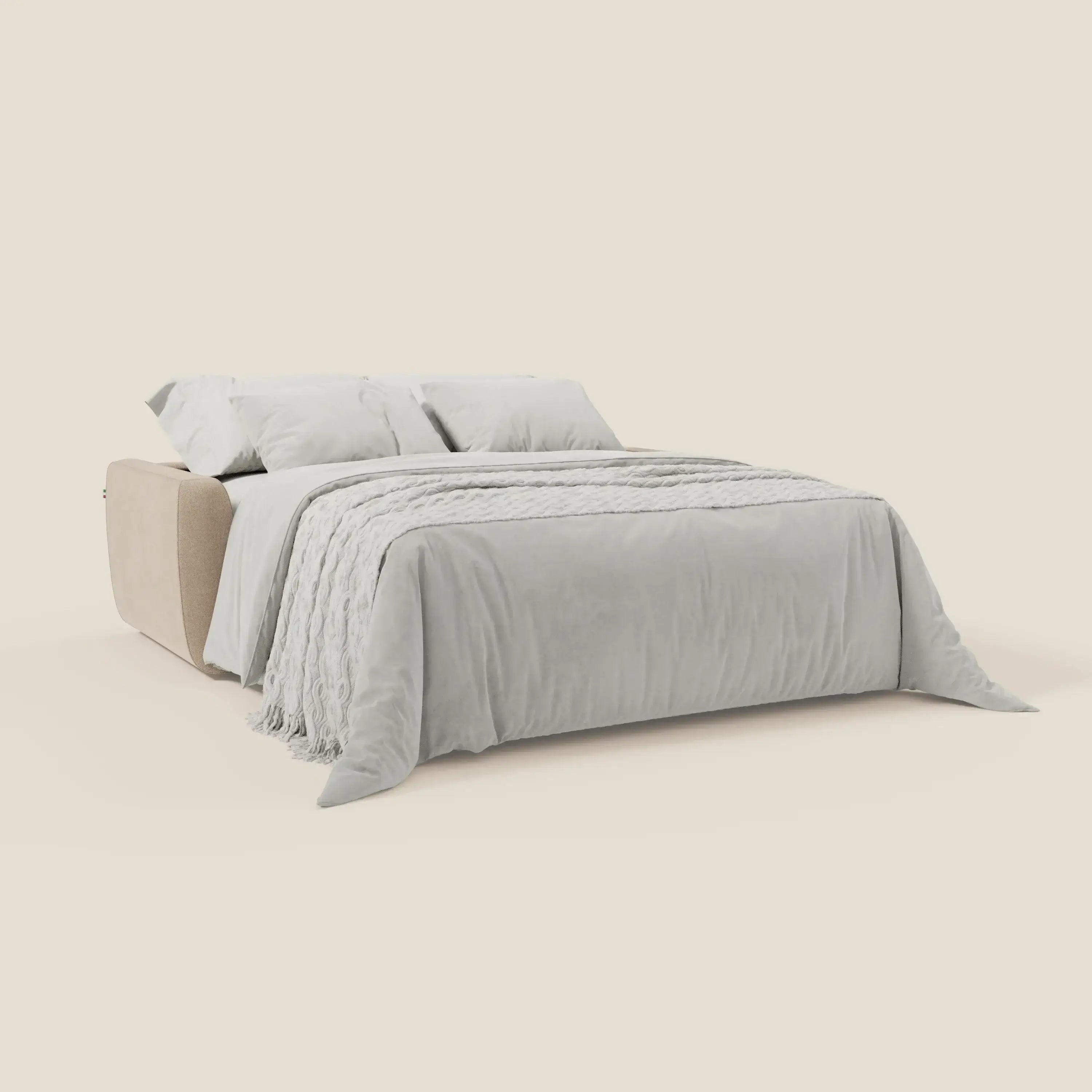 Il divano letto sfoderabile Leonida di Divani.Store in beige T23 antimacchia è caratterizzato da un look moderno, materasso H18 cm per il massimo comfort, biancheria da letto grigio chiaro, cuscini coordinati, un copriletto testurizzato e un fondo crema con contenitore per i cuscini.