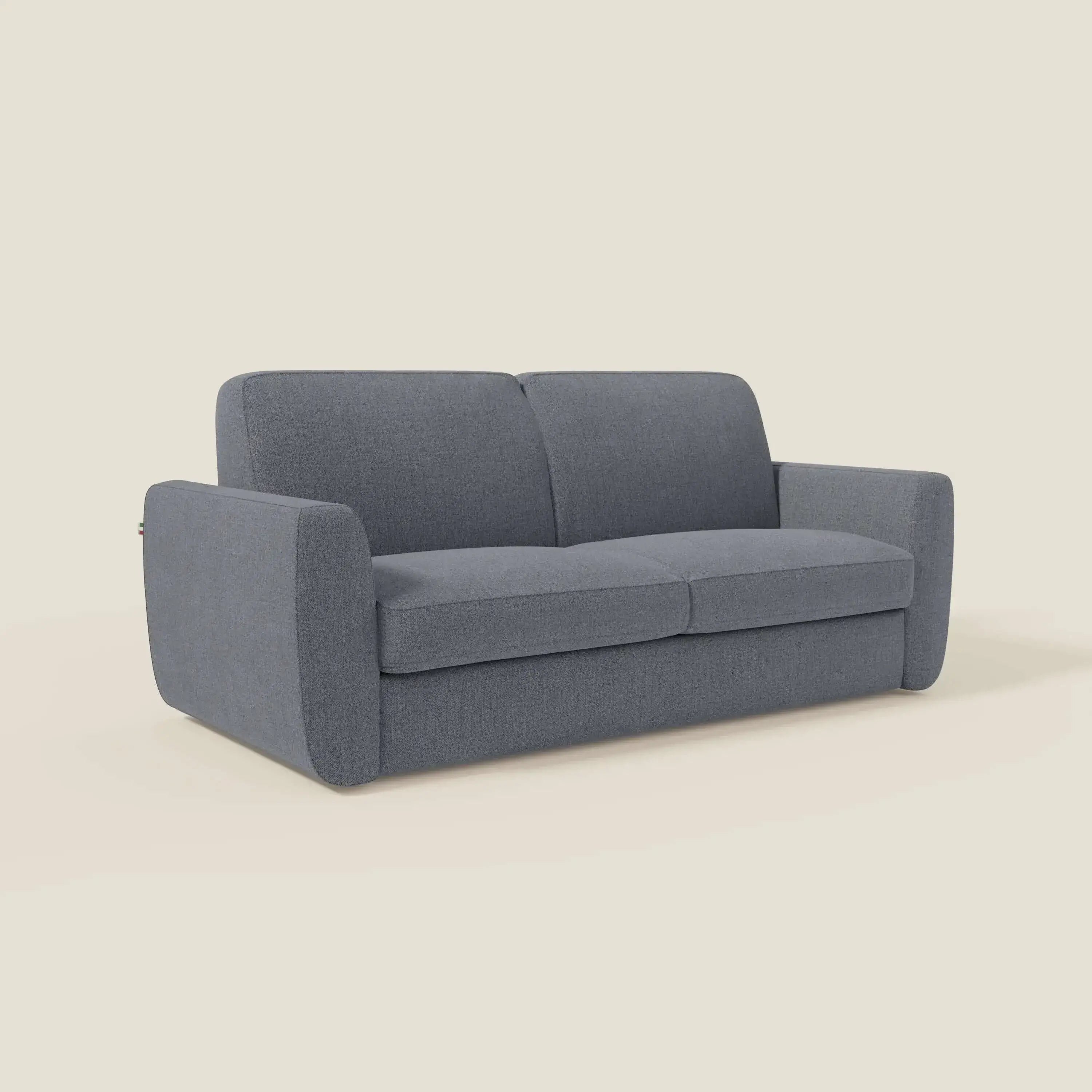 Il divano letto sfoderabile Leonida di Divani.Store, in tessuto smacchiabile T23 blu grafite con materasso H18 cm e cuscino contenitore, è caratterizzato da braccioli dritti e cuscini rigidi per un look pulito e minimalista su sfondo beige.