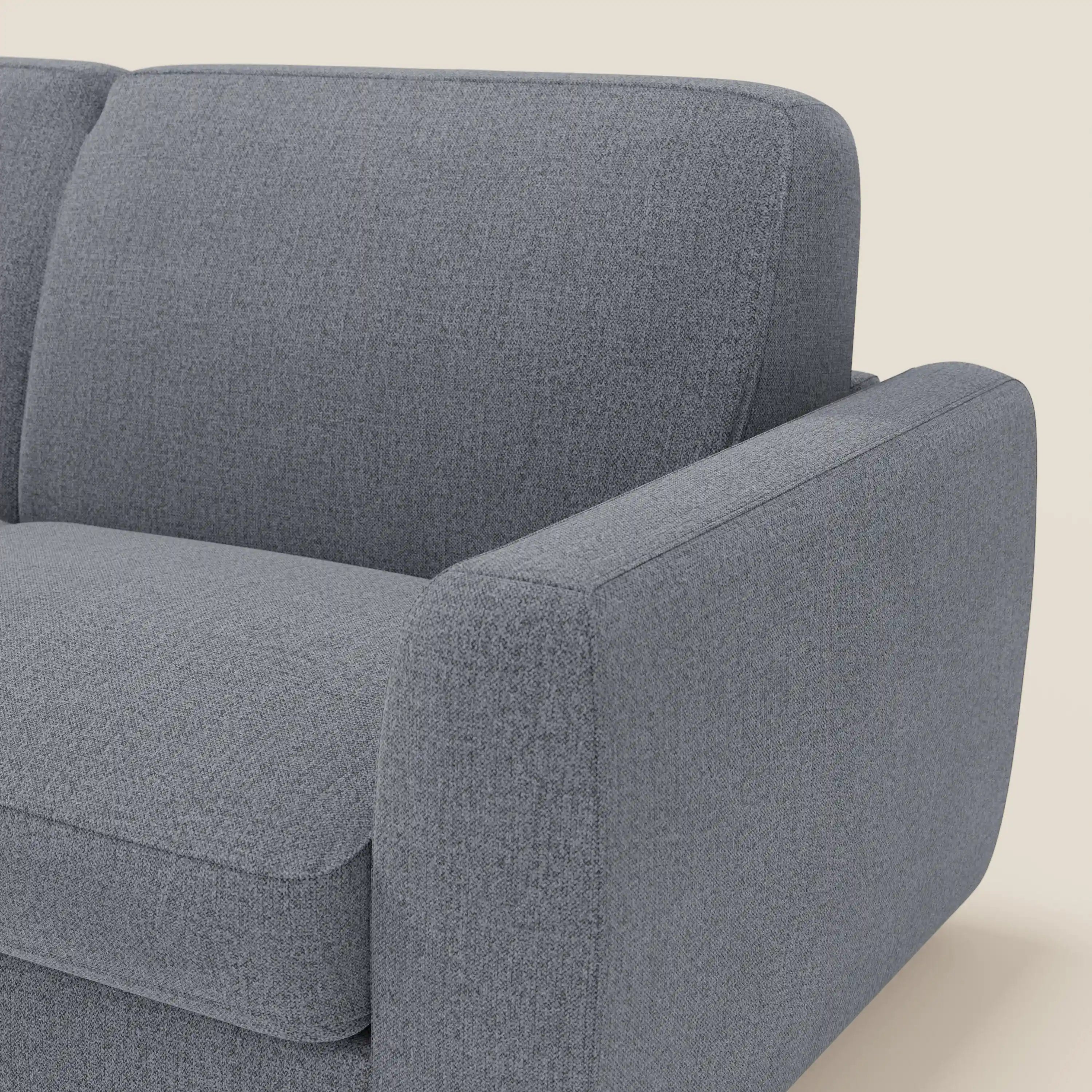 Primo piano del divano letto sfoderabile Leonida di Divani.Store, in tessuto smacchiabile T23 blu grafite. L'immagine evidenzia il bracciolo destro, lo schienale e il cuscino di seduta dalle linee pulite e dallo stile minimalista su uno sfondo beige.