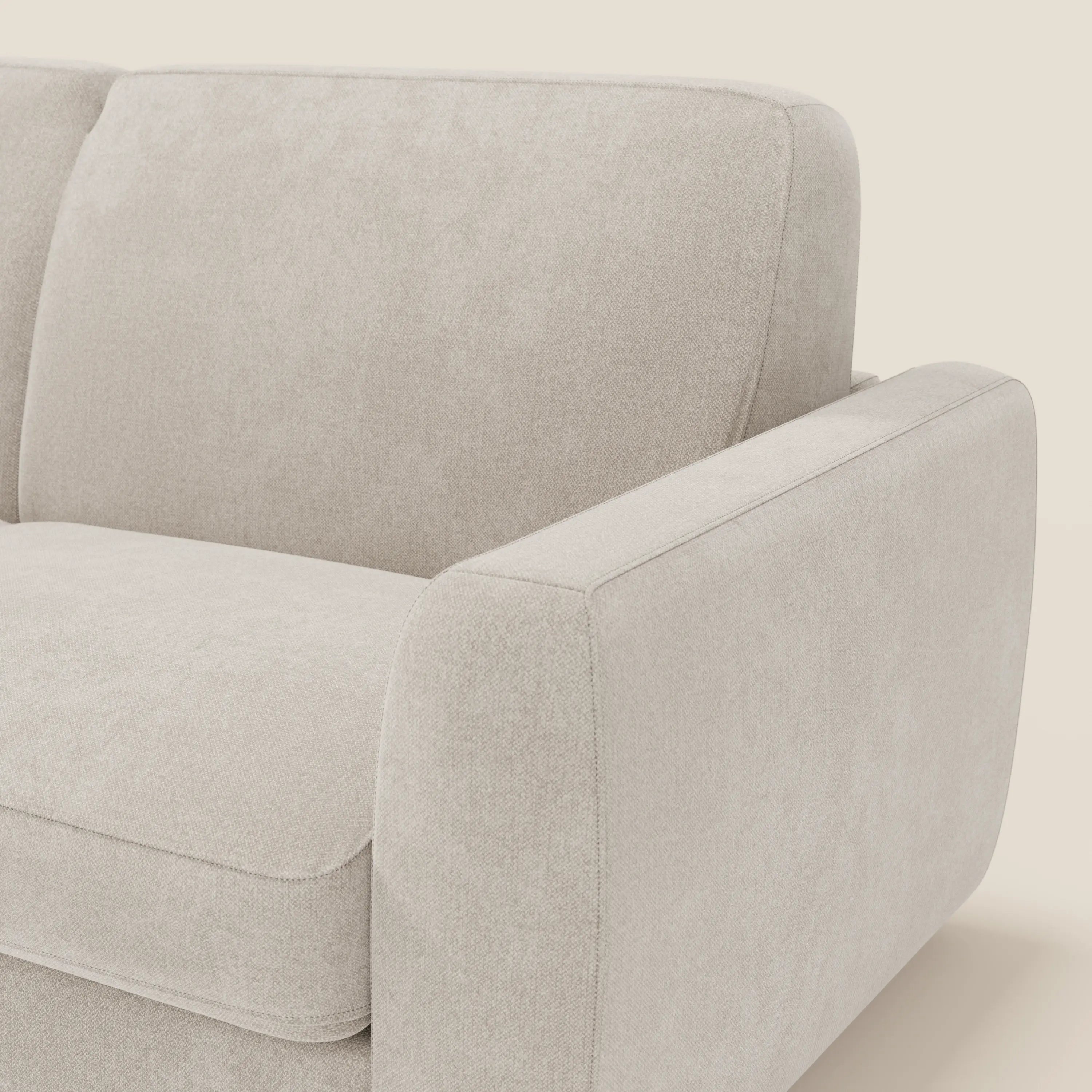 Primo piano del divano letto sfoderabile Leonida di Divani.Store in Smacchiabile T23 panna, con rivestimento sfoderabile, materasso ad alta densità H18 cm, portaguanciali, linee morbide e arrotondate e imbottitura in tessuto.