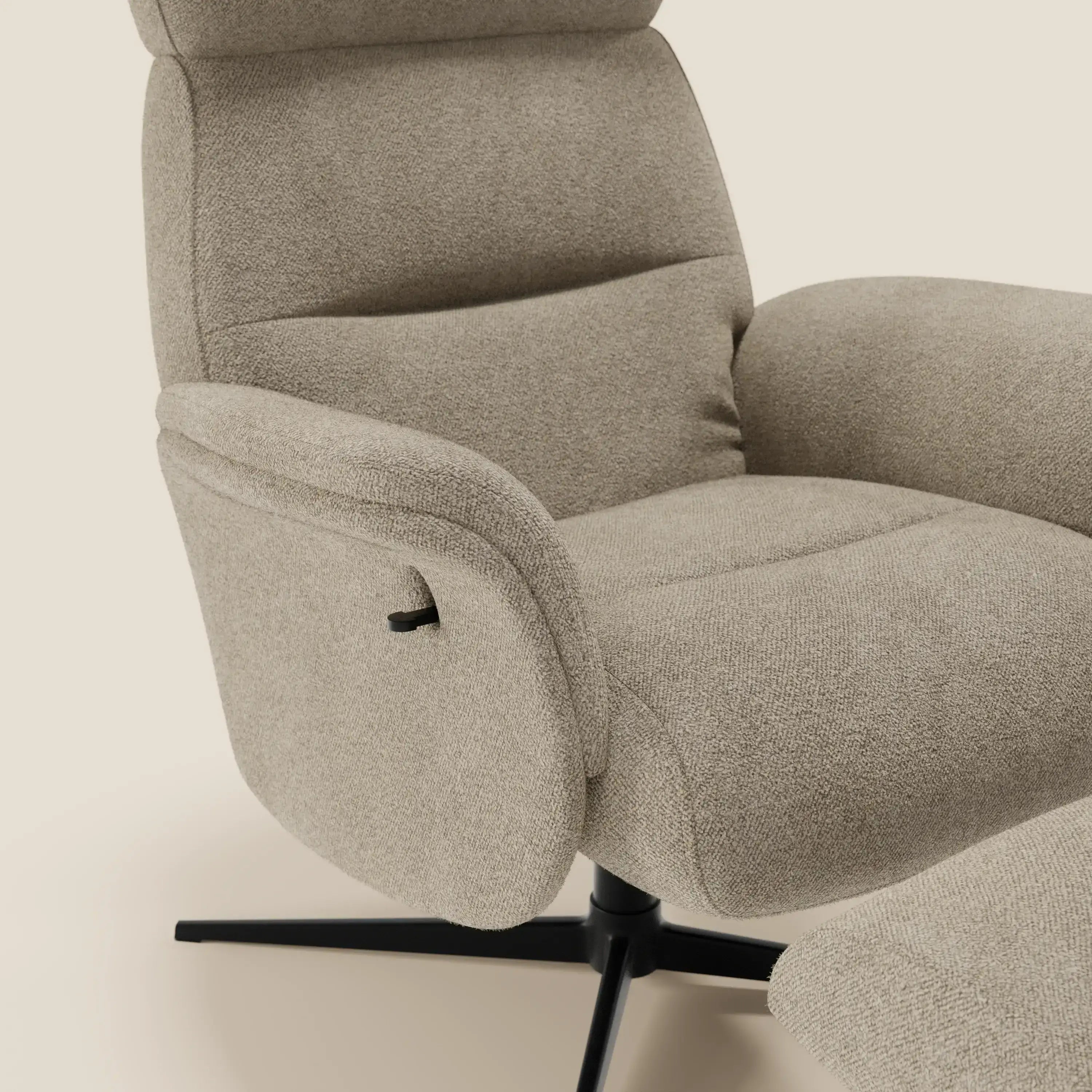 Primo piano della Poltrona relax reclinabile Lunor di Divani.Store, rivestita in bouclé impermeabile beige T07. Presenta spessi braccioli imbottiti, una leva di reclinazione nera e una base girevole a quattro gambe in metallo nero con pouf poggiapiedi.