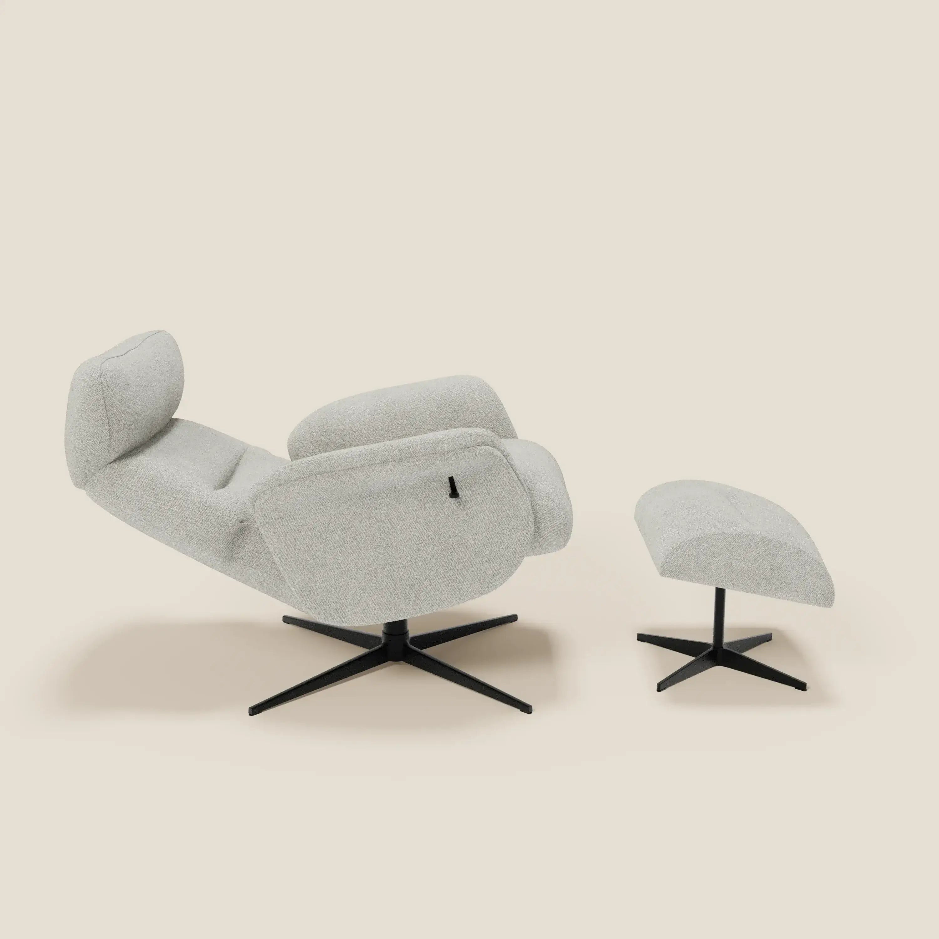 La poltrona relax Lunor di Divani.Store, con rivestimento bouclé bianco T07 impermeabile e pouf coordinato su base girevole nera, è ambientata su uno sfondo beige neutro ed è mostrata in posizione reclinata.