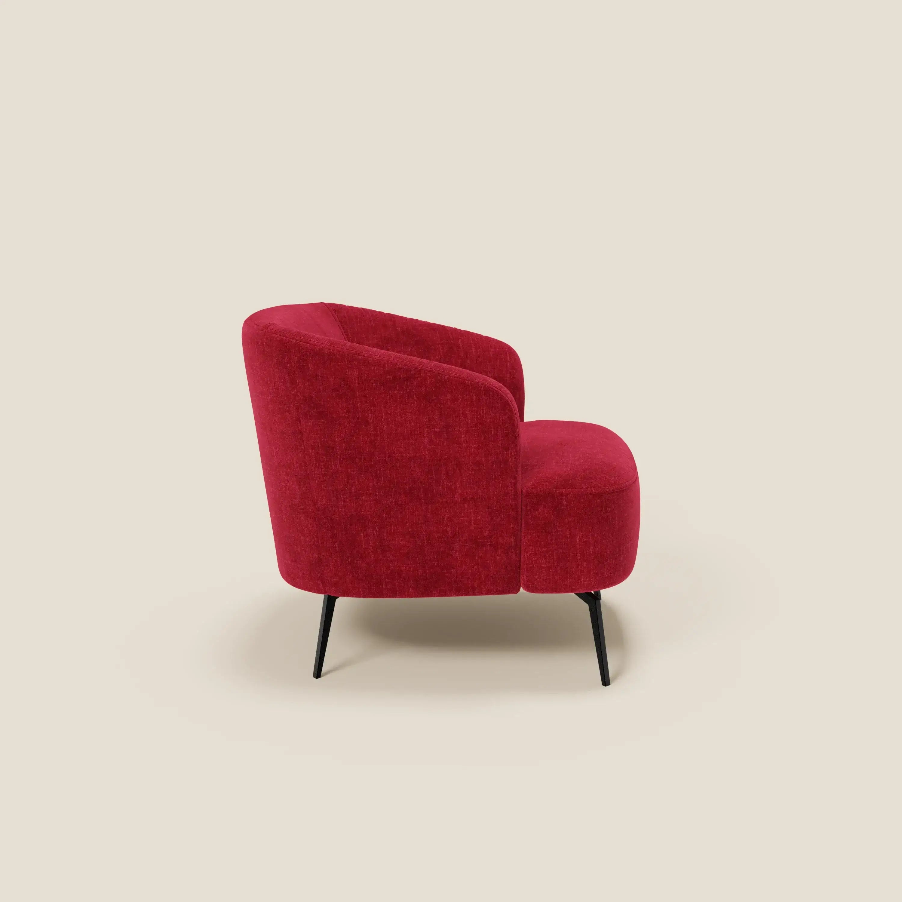 La poltroncina Renoa dall'eleganza moderna di Divani.Store, in smacchiabile T24 rosso bordeaux, si presenta di profilo con schienale curvo, seduta arrotondata e sottili gambe in metallo nero su sfondo crema.