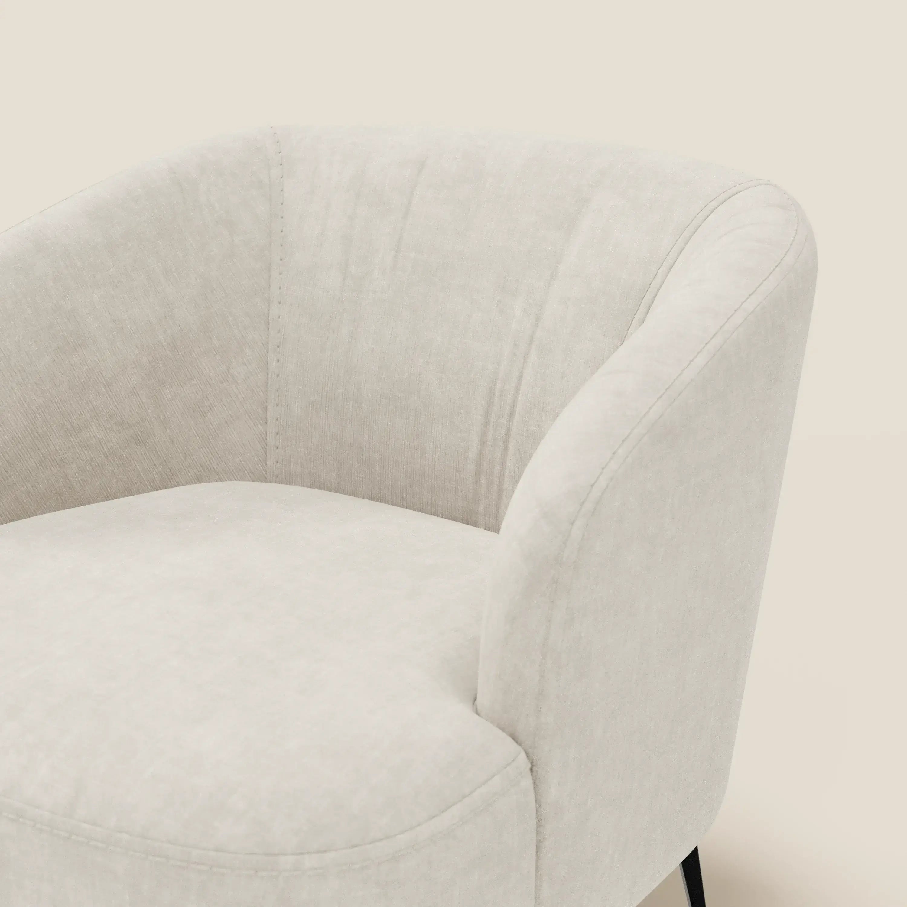 La poltroncina Renoa di Divani.Store è caratterizzata da un'eleganza moderna in tessuto smacchiabile T24 bianco latte, con schienale curvo, braccioli, sottili cuciture verticali e sottili gambe in metallo nero per garantire comfort e stile.