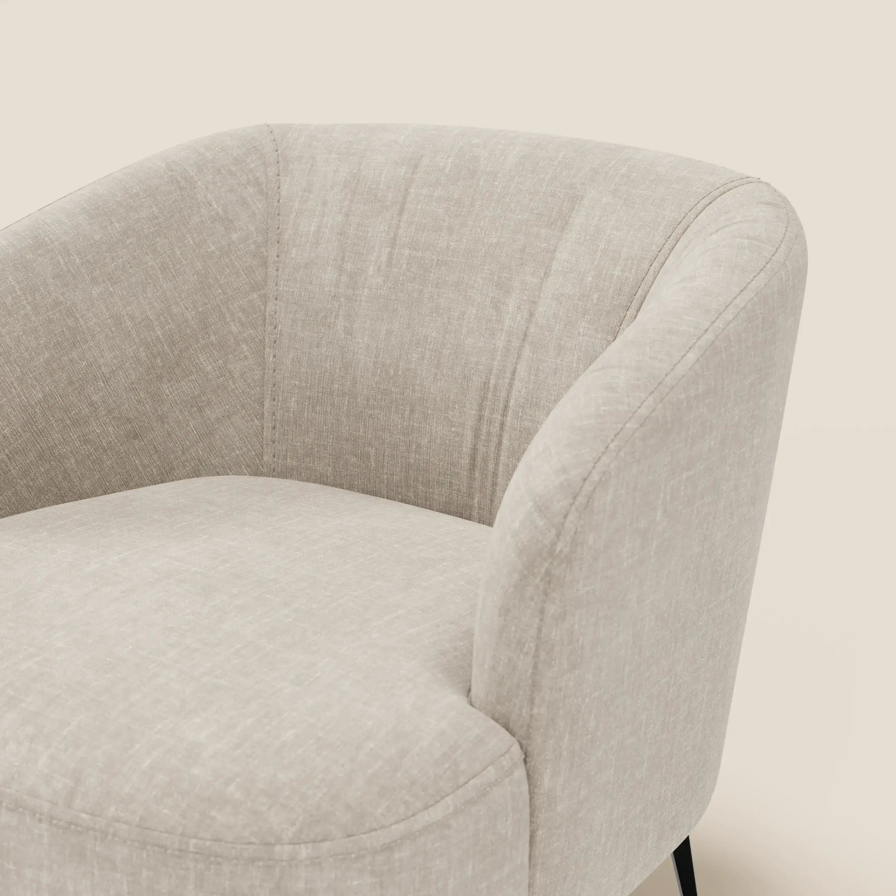 Primo piano della poltroncina Renoa di Divani.Store, caratterizzata da un'eleganza moderna con tessuto antimacchia in lino chiaro T24, schienale e braccioli arrotondati e sottili gambe in metallo nero su sfondo bianco sporco.