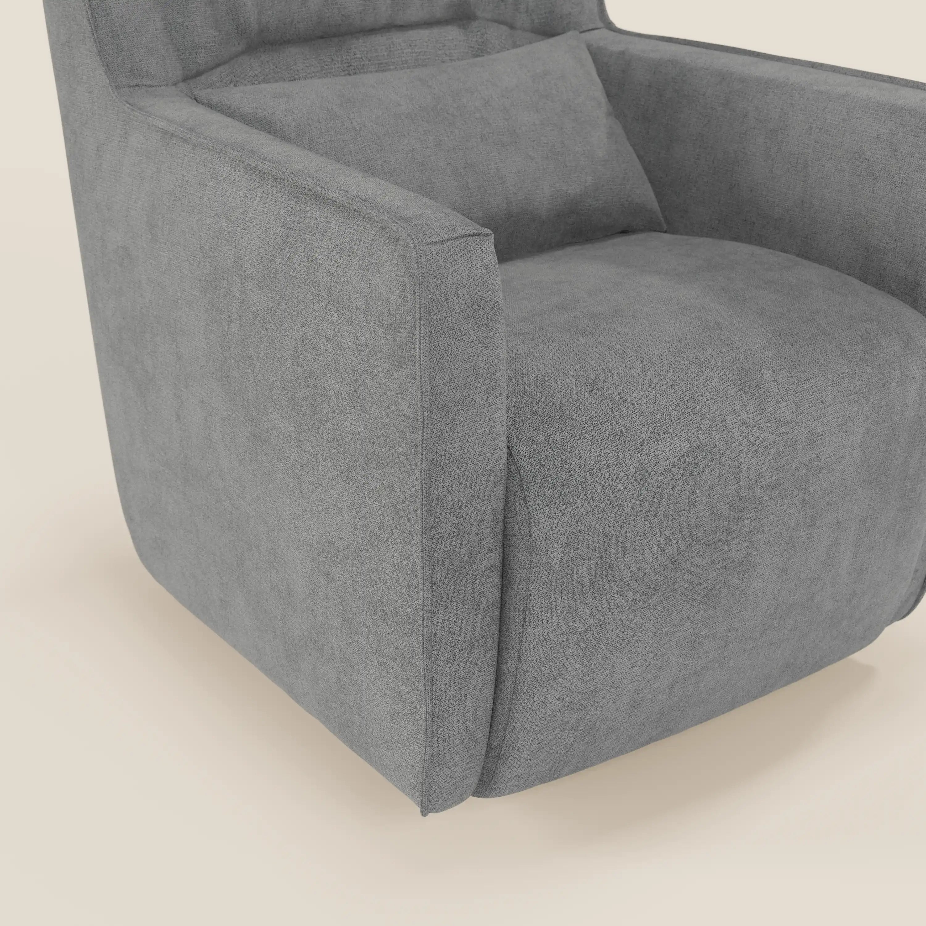 Primo piano della poltrona girevole Tulla in tessuto impermeabile T02 grigio di Divani.Store, caratterizzata da linee pulite, cuscino di seduta spesso, cuscino rettangolare coordinato, ampi braccioli e tessuto grigio morbido su sfondo beige.