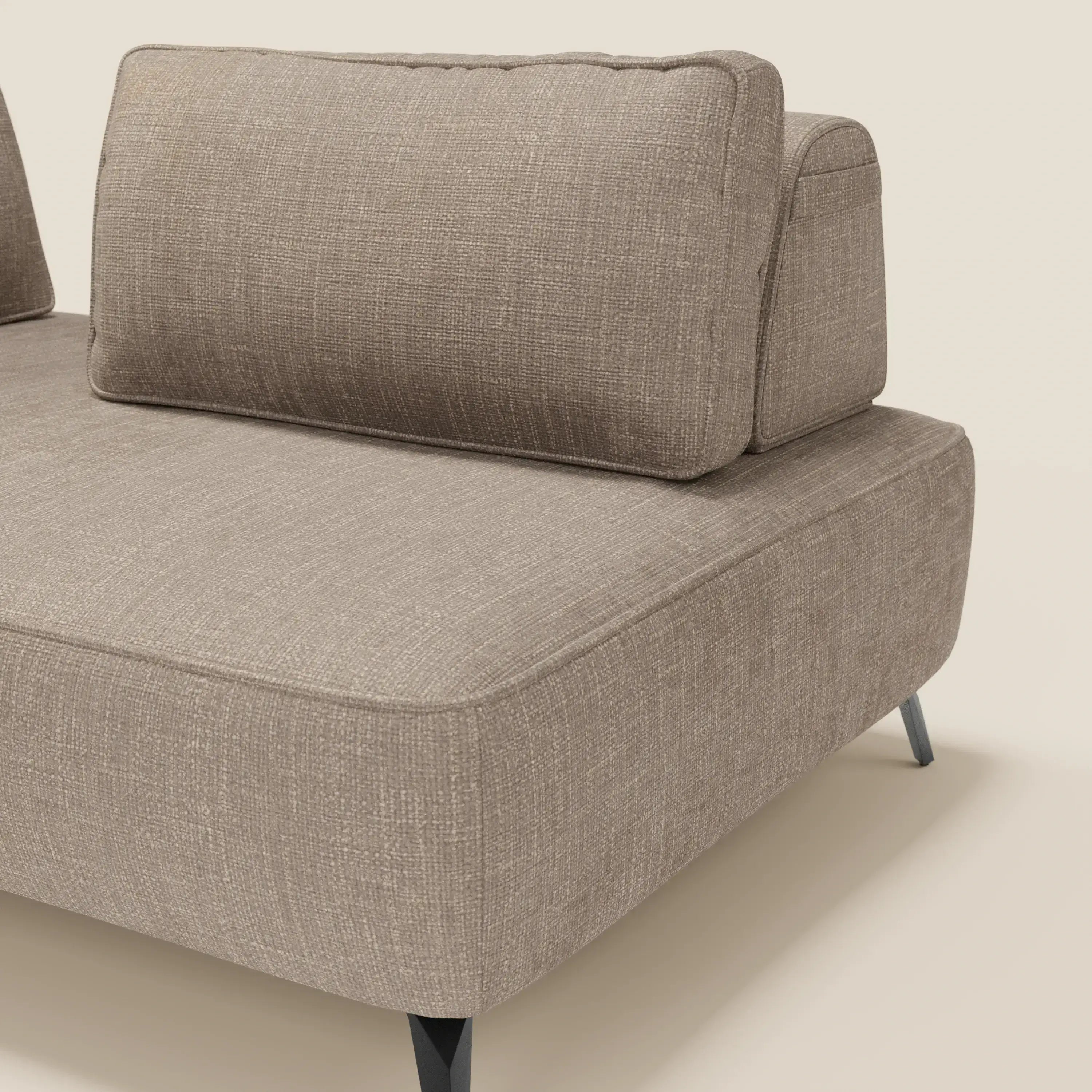 Un primo piano del divano modulare Volta con schienali mobili in tessuto ciniglia T06 tortora di Divani.Store, caratterizzato da spessi cuscini di seduta e sottili gambe in metallo nero, incarna un design contemporaneo su uno sfondo crema chiaro.