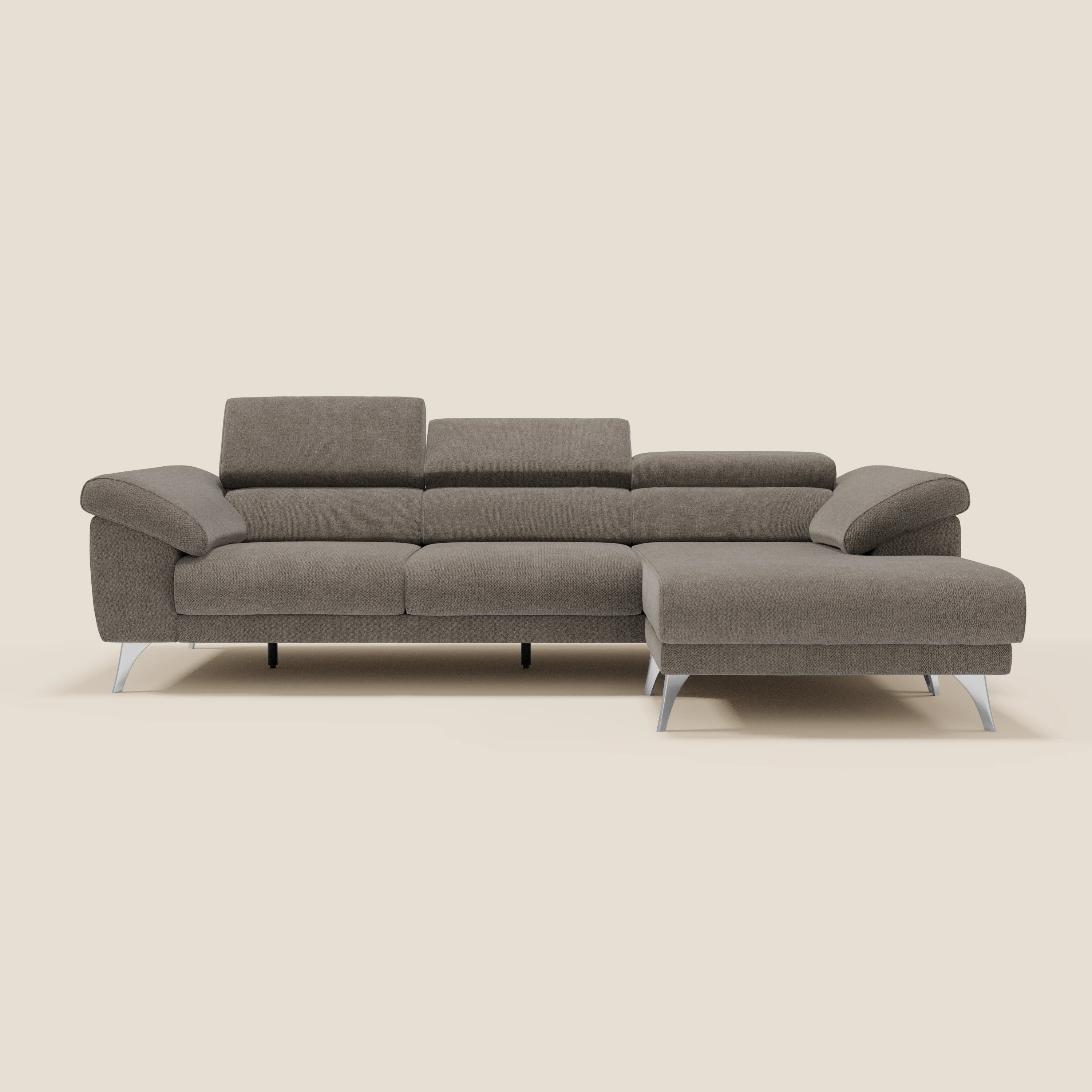Il Donatello Divano angolare di Divani.Store è caratterizzato da sedute scorrevoli, braccioli contenitore, poggiatesta e morbido rivestimento antimacchia T23 taupe con chaise lounge reversibile, il tutto su uno sfondo crema.
