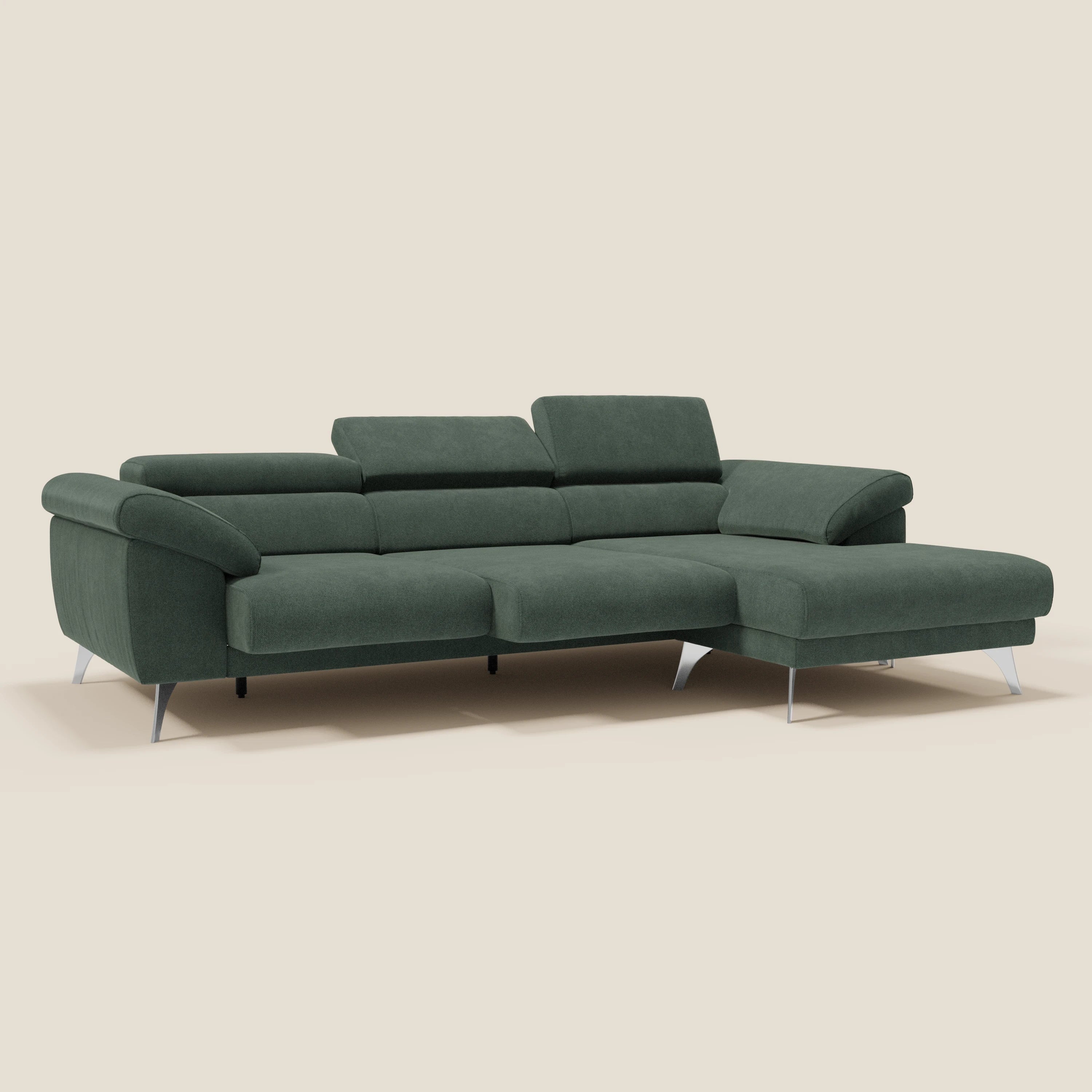 Il Donatello Divano angolare di Divani.Store è un divano a L in tessuto antimacchia verde T23, con sedute scorrevoli, braccioli contenitori e poggiatesta regolabili; la chaise si estende a destra, su uno sfondo beige chiaro.