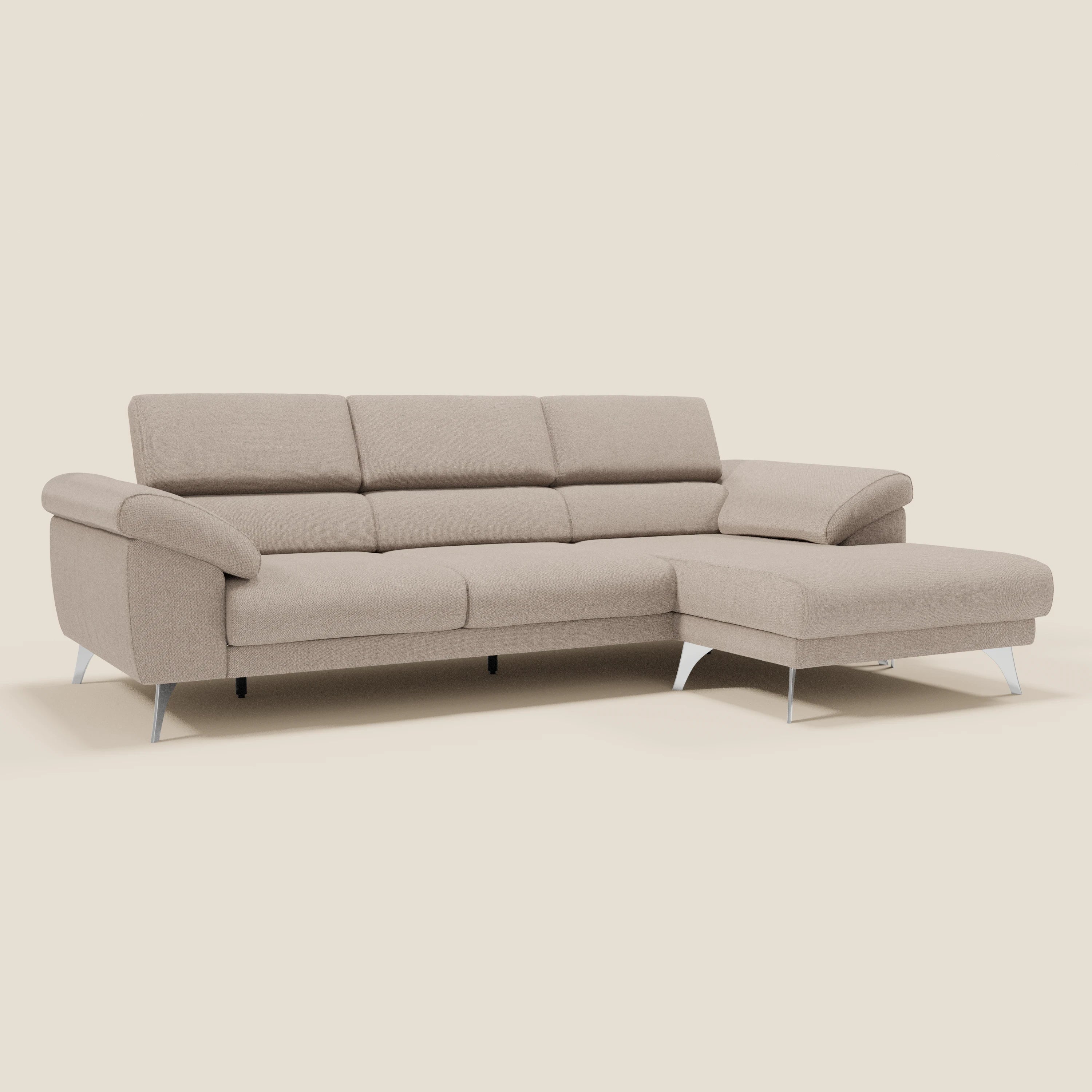 Il Donatello Divano angolare di Divani.Store è caratterizzato da sedute scorrevoli, braccioli contenitore, poggiatesta regolabile e tessuto tortora T23 morbido e smacchiabile. Questo moderno divano beige è dotato di una chaise longue destra e di eleganti gambe in metallo su uno sfondo color crema.