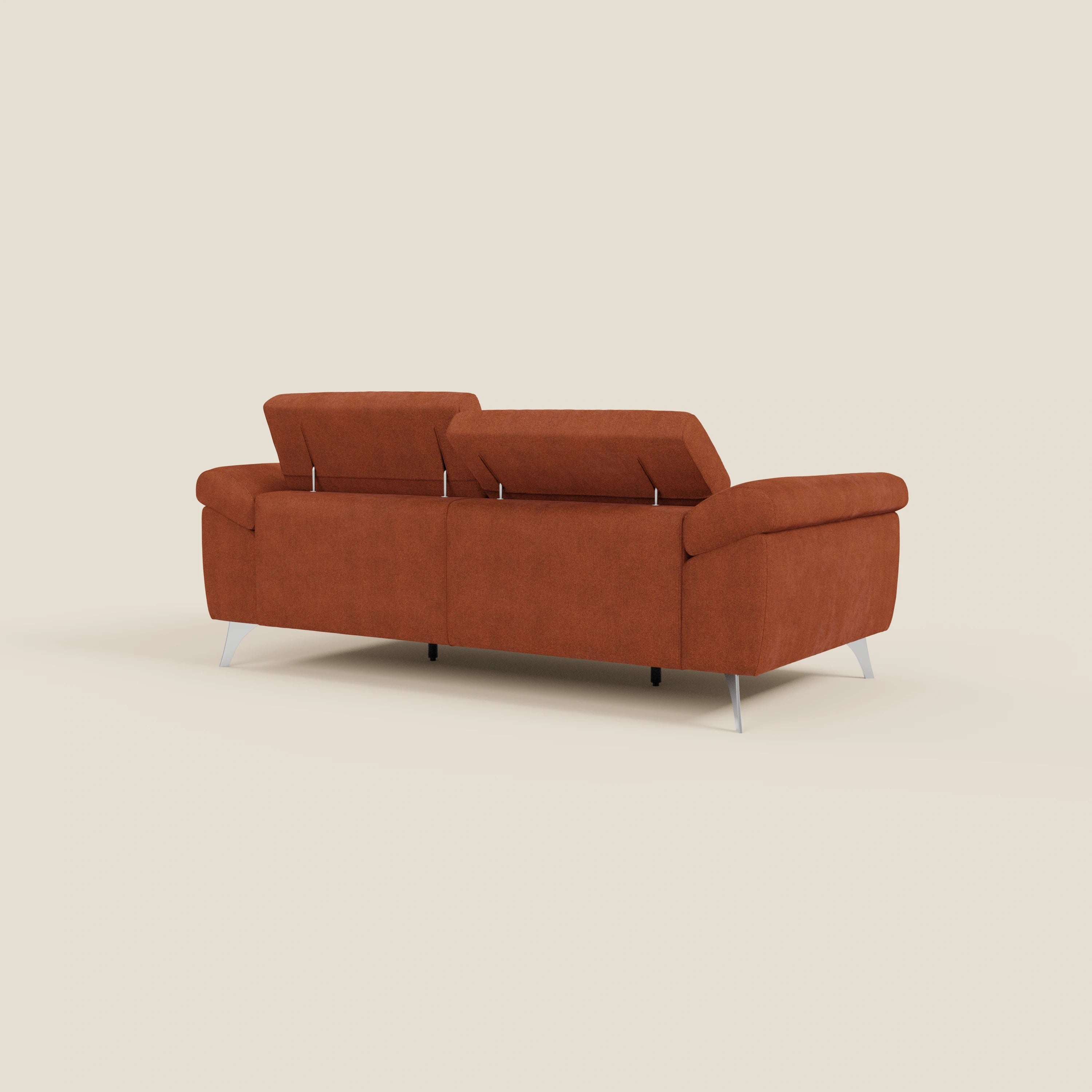 Un divano Donatello di Divani.Store in arancione ruggine T23 tessuto smacchiabile, con sedute allungabili, braccioli contenitore e reclinabili poggiatesta, si distingue per le sue linee pulite e il suo fascino moderno su uno sfondo beige chiaro.