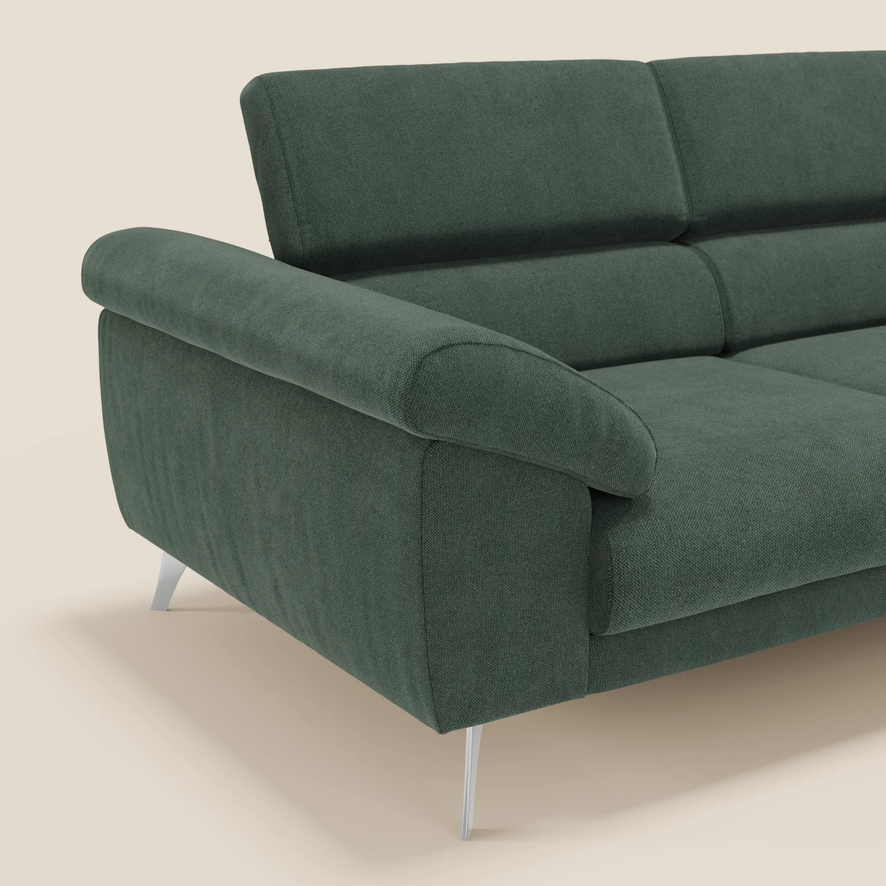 Il divano Donatello di Divani.Store in tessuto verde smacchiabile T23 è caratterizzato da sedute allungabili, braccioli contenitore e poggiatesta reclinabili. Le gambe argentate e il rivestimento strutturato spiccano su uno sfondo beige chiaro.