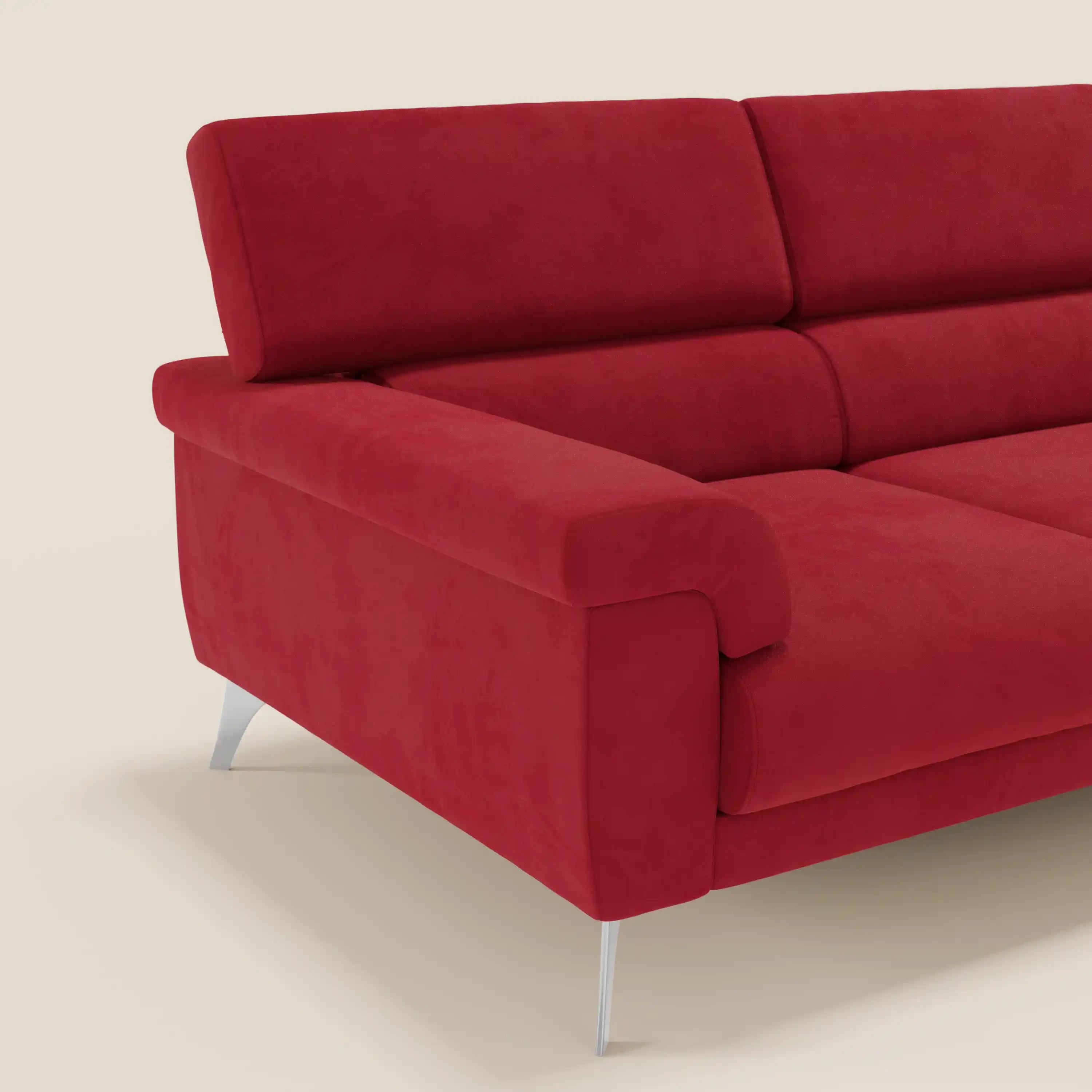 Angolo del divano angolare Raffaello di Divani.Store in microfibra antimacchia T11 rossa, con sedute scorrevoli, poggiatesta regolabili, imbottitura morbida, ampio bracciolo imbottito e gambe angolari in metallo su sfondo beige chiaro.
