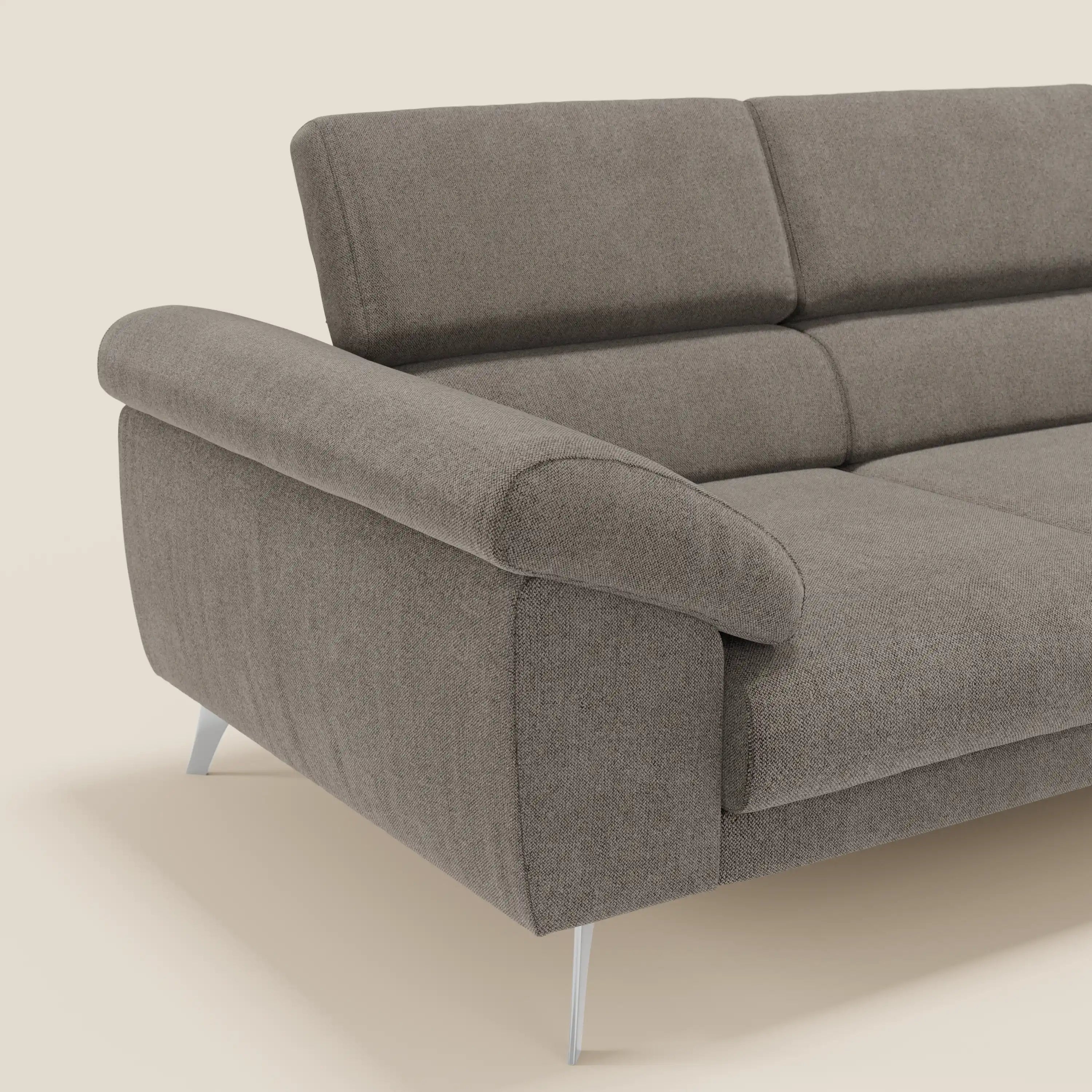 Il divano Donatello di Divani.Store è caratterizzato da 3 sedute estensibili, braccioli contenitori e poggiatesta reclinabili in tessuto T23 taupe, facile da pulire, che fonde comfort moderno e funzionalità su un semplice sfondo bianco sporco.