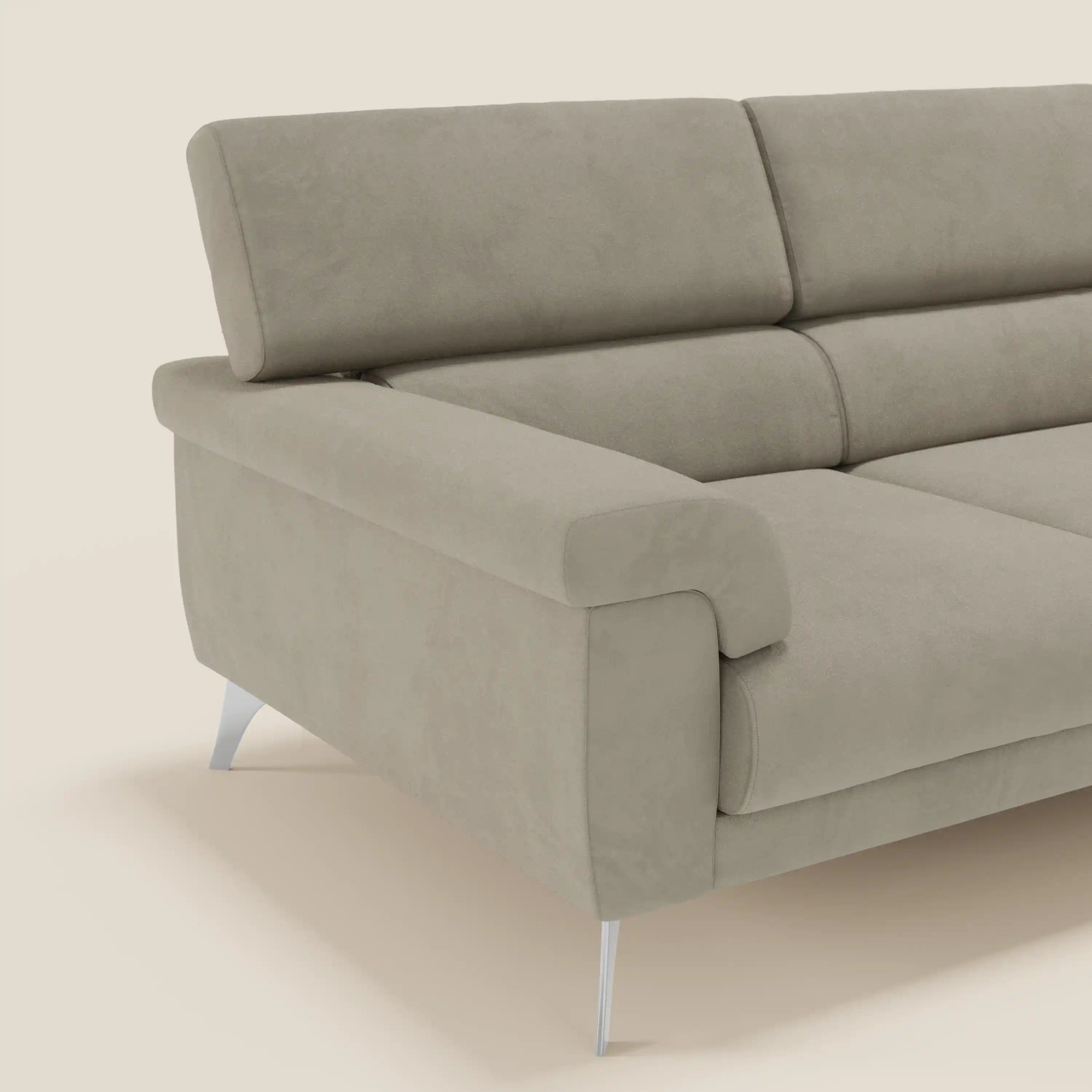 Un primo piano del divano angolare Raffaello di Divani.Store, caratterizzato da sedute scorrevoli, poggiatesta regolabili e un morbido rivestimento in microfibra smacchiabile T11 tortora che ne esalta il design moderno su uno sfondo neutro.