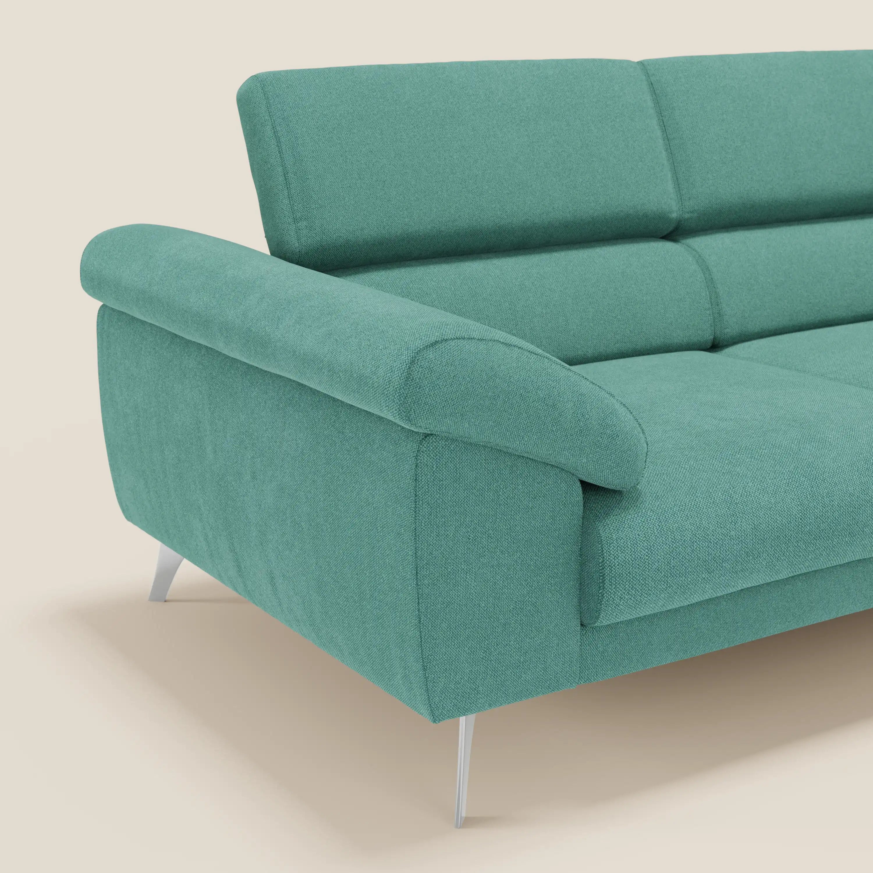 Un primo piano del divano Donatello di Divani.Store in T23 verde acqua, caratterizzato da sedute in feltro, braccioli contenitori e poggiatesta reclinabili. Il suo design contemporaneo spicca su uno sfondo crema chiaro; solo una parte del divano è visibile.