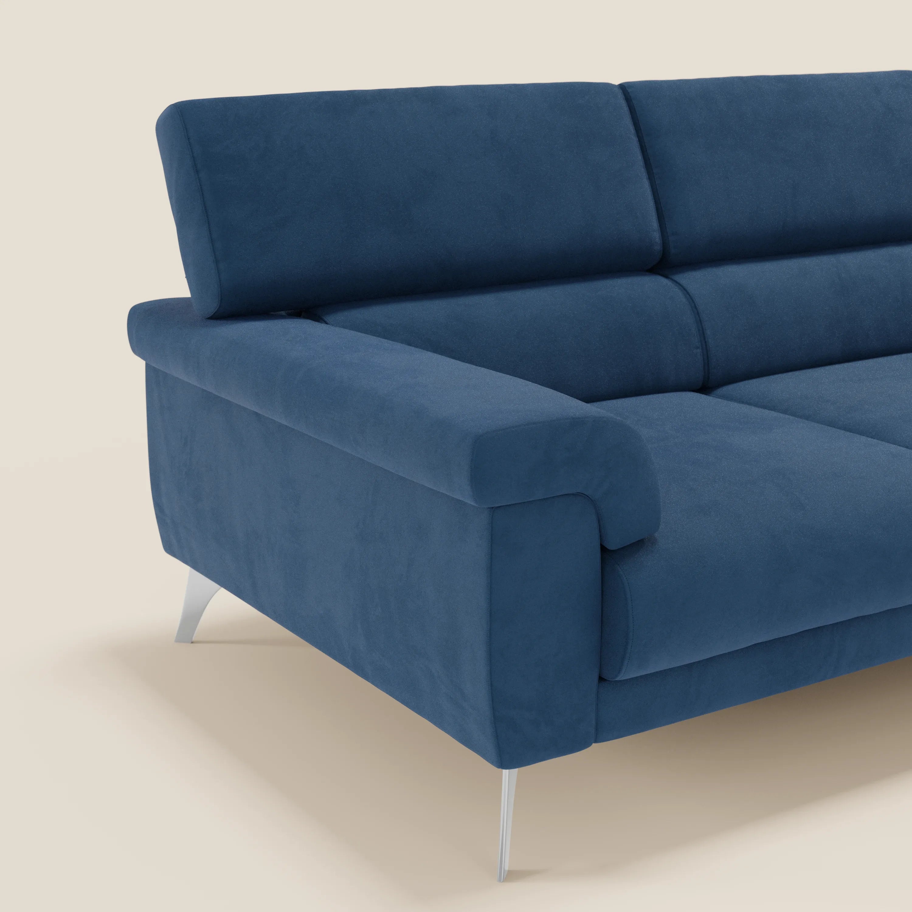 Primo piano del Raffaello Divano angolare con sedute scorrevoli e poggiatesta regolabili in microfibra smacchiabile T11 blu di Divani.Store, con ampi braccioli e gambe angolari in argento, su sfondo beige.