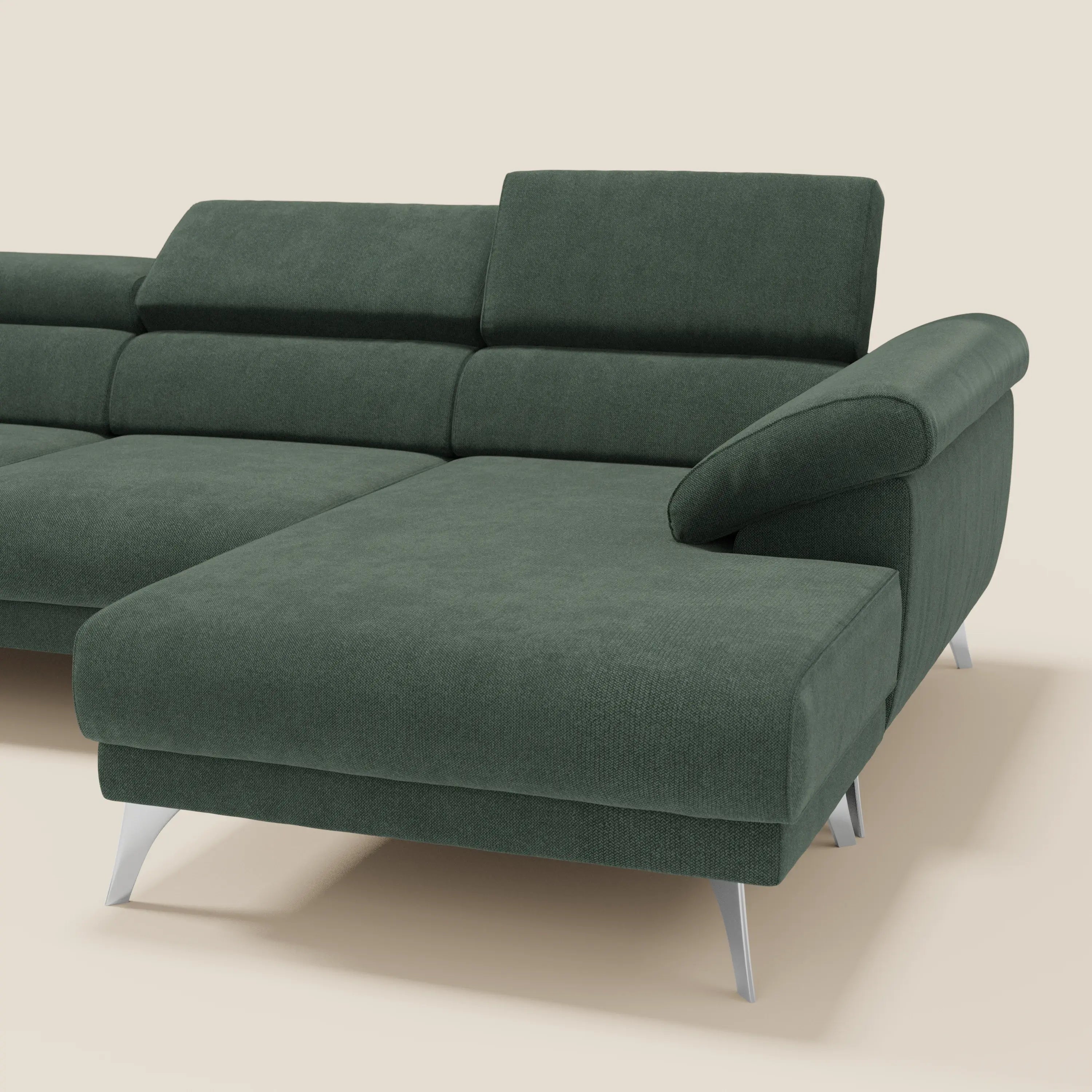 Il Donatello Divano angolare di Divani.Store è caratterizzato da sedute scorrevoli, braccioli contenitore, poggiatesta e morbido tessuto antimacchia verde T23 con eleganti gambe argentate, su sfondo beige.