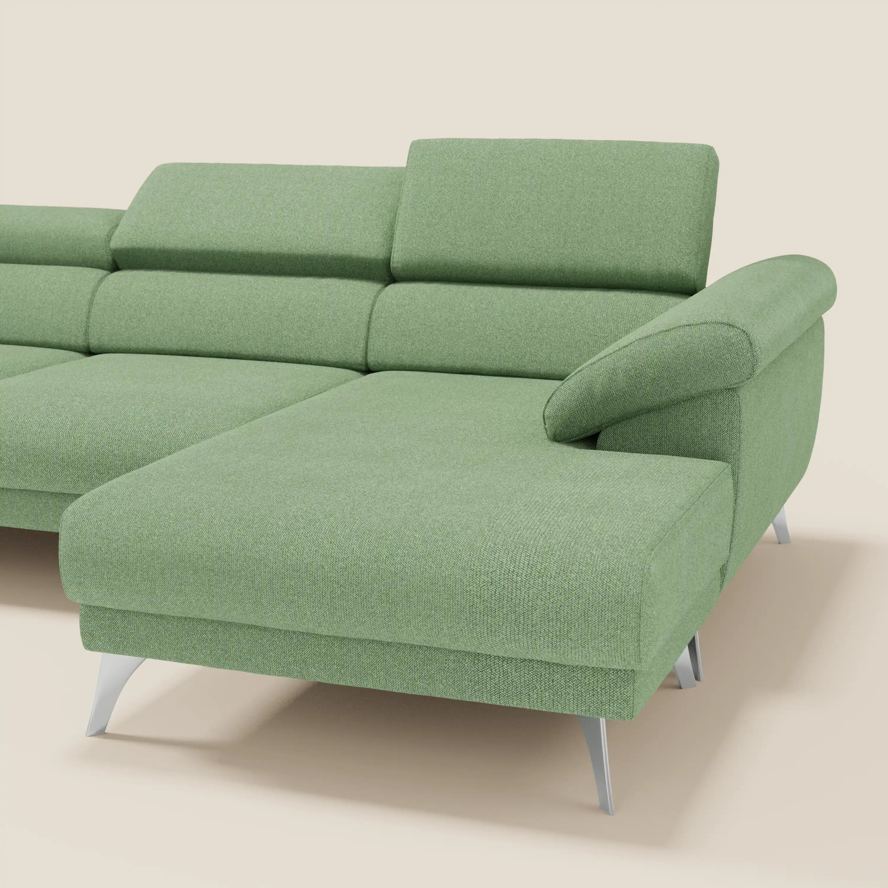 Il Donatello Divano angolare di Divani.Store, in morbido tessuto T23 menta antimacchia, è caratterizzato da sedute scorrevoli, braccioli contenitori e poggiatesta regolabili, con una chaise longue a sinistra, su sfondo beige.