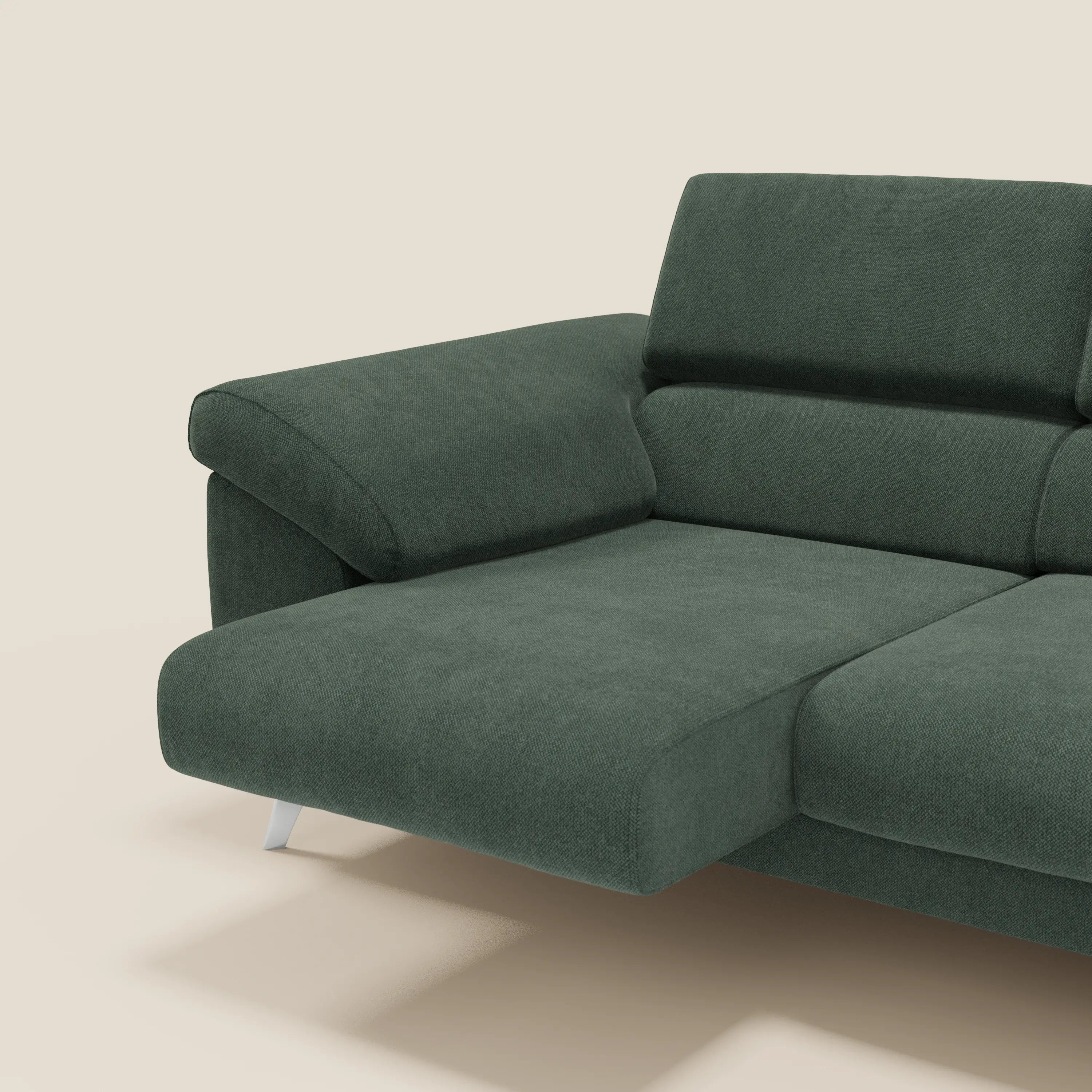 Il divano Donatello di Divani.Store è caratterizzato da 3 sedute allungabili, braccioli contenitori e poggiatesta reclinabili in tessuto antimacchia verde T23, con ampio bracciolo e gambe in metallo su sfondo beige. Sono visibili solo il lato sinistro e parte della seduta.