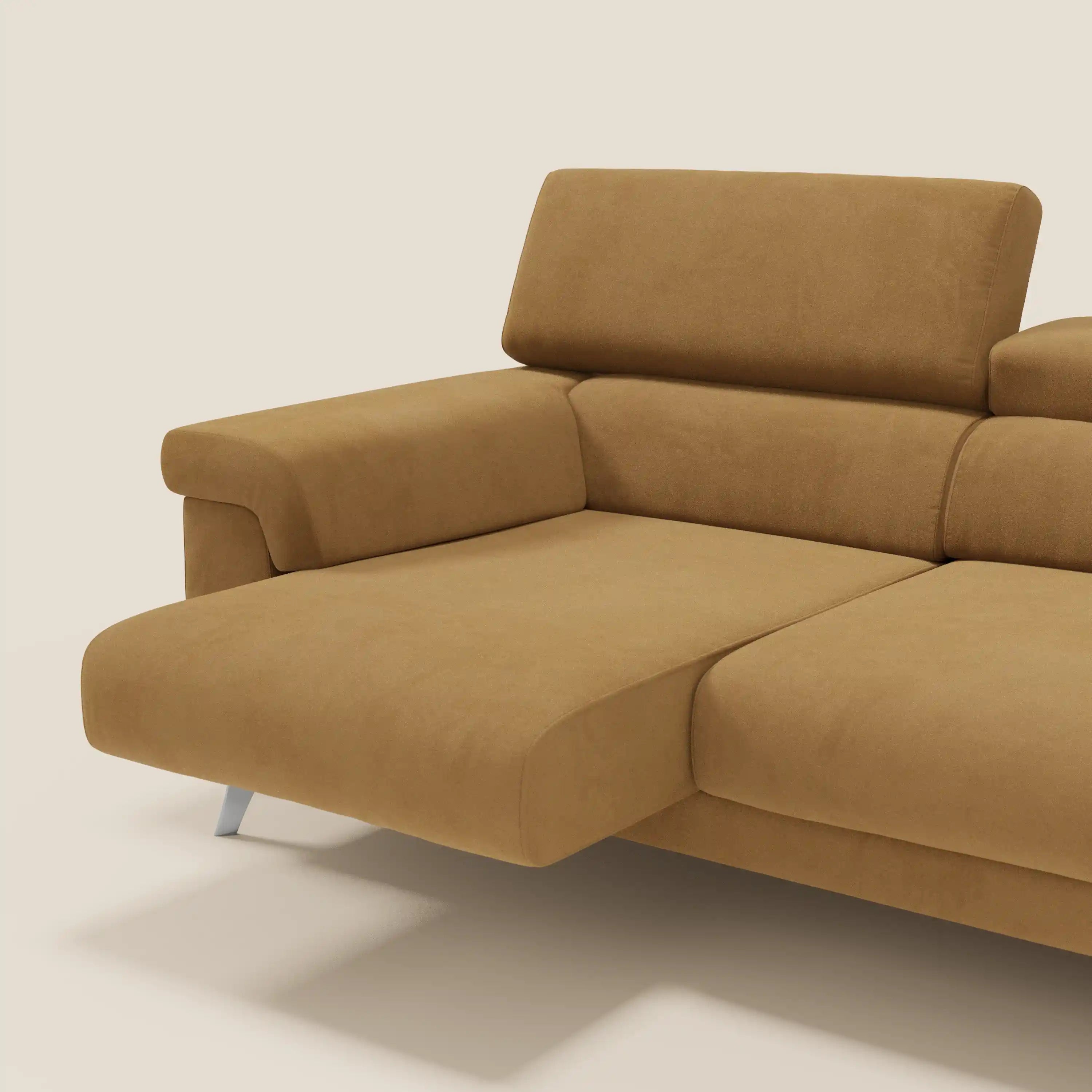 Il divano Raffaello di Divani.Store è caratterizzato da 3 sedute allungabili, poggiatesta reclinabili e microfibra antimacchia T11 cuoio. La sezione chaise, i cuscini e le gambe in metallo lucido aggiungono uno stile moderno su uno sfondo beige.