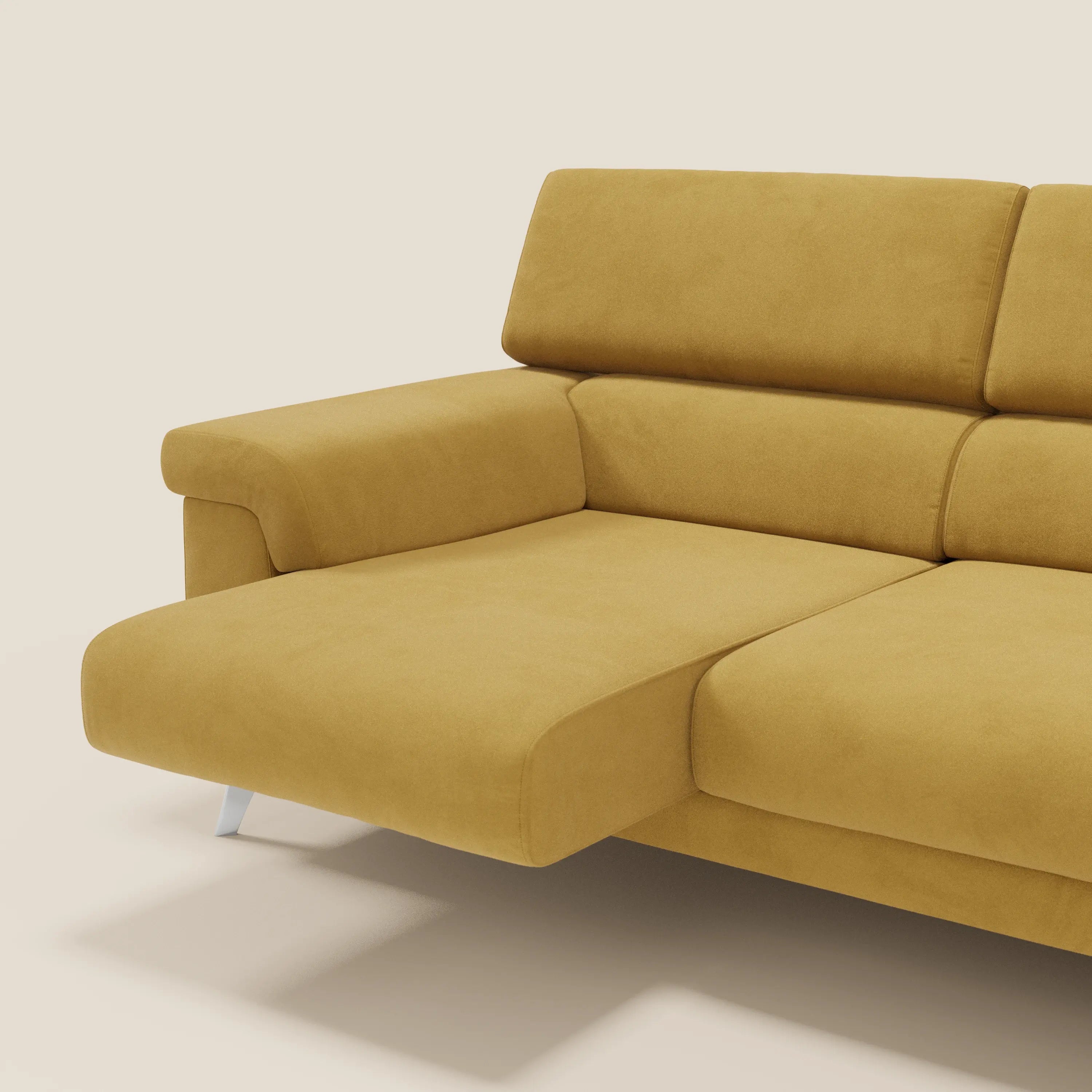 Il Raffaello Divano angolare di Divani.Store in T11 giallo è caratterizzato da sedute scorrevoli, poggiatesta regolabili, rivestimento in microfibra smacchiabile e gambe angolari argentate, su uno sfondo beige chiaro.