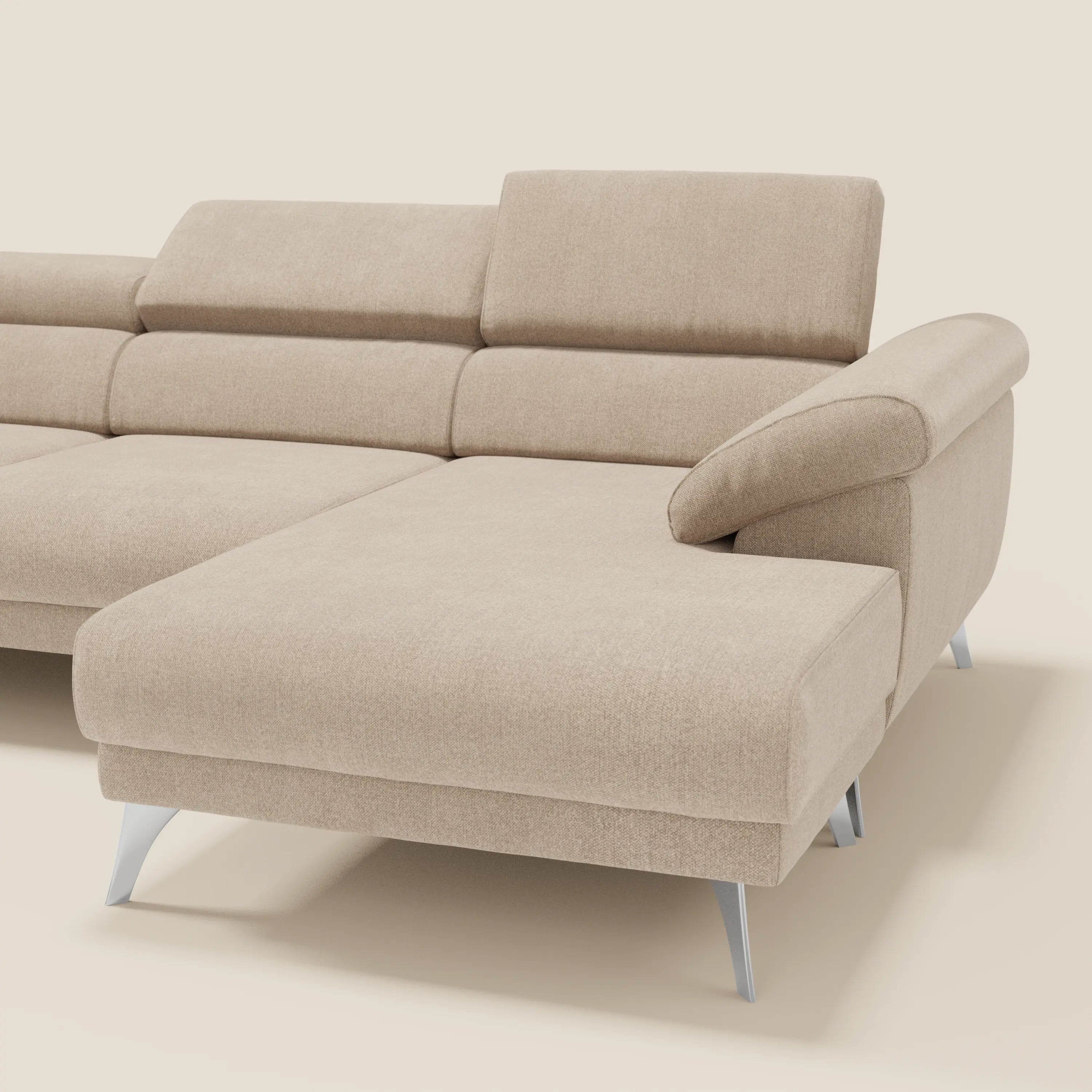 Il divano angolare Donatello di Divani.Store in smacchiabile T23 beige è caratterizzato da sedute scorrevoli, braccioli contenitore, poggiatesta regolabili e gambe in metallo, con un look moderno su uno sfondo bianco sporco.