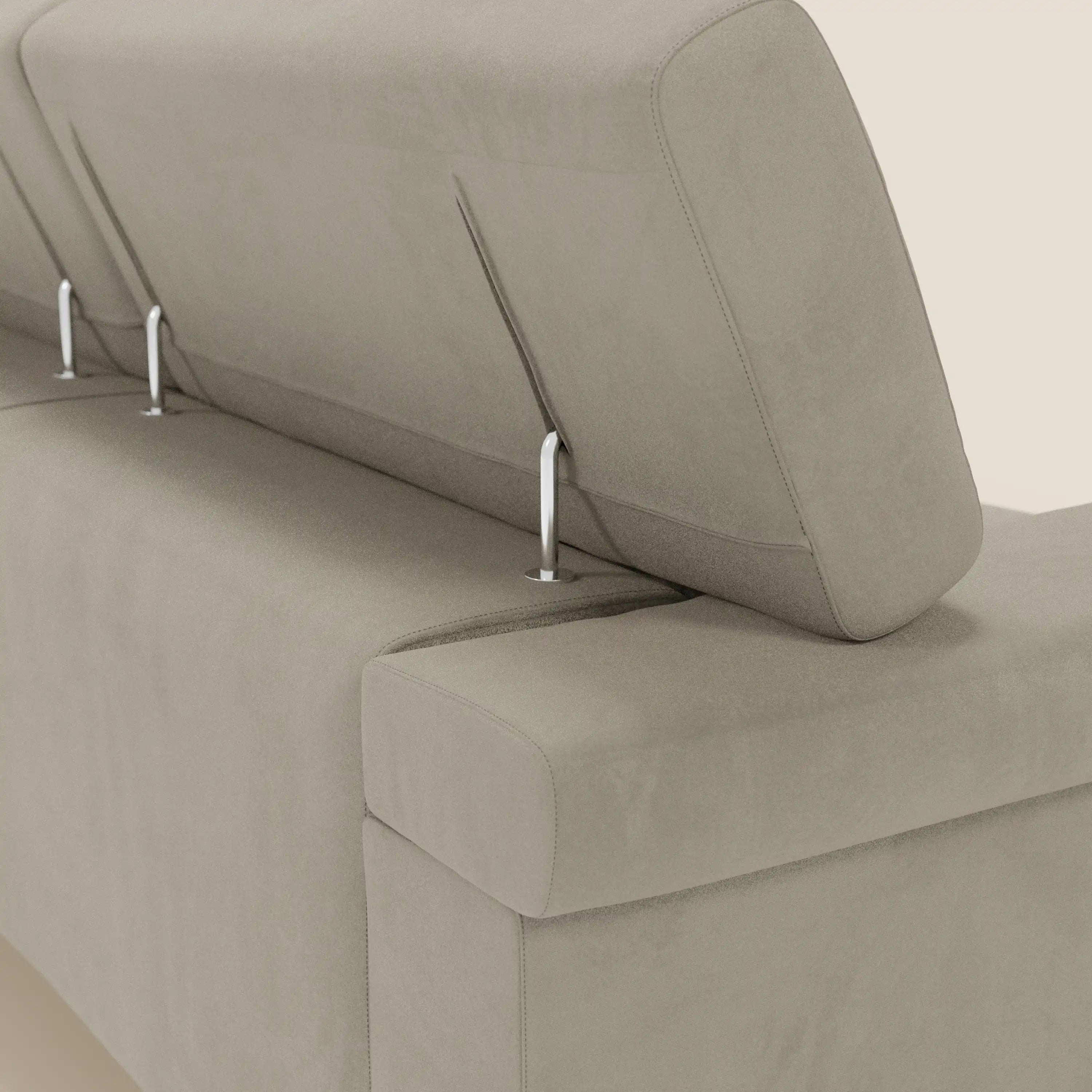 Un primo piano del Raffaello Divano angolare di Divani.Store in microfibra smacchiabile T11 tortora, dotato di sedute scorrevoli e poggiatesta regolabili con aste metalliche, mette in evidenza il suo rivestimento felpato e il design moderno e minimalista su uno sfondo semplice.