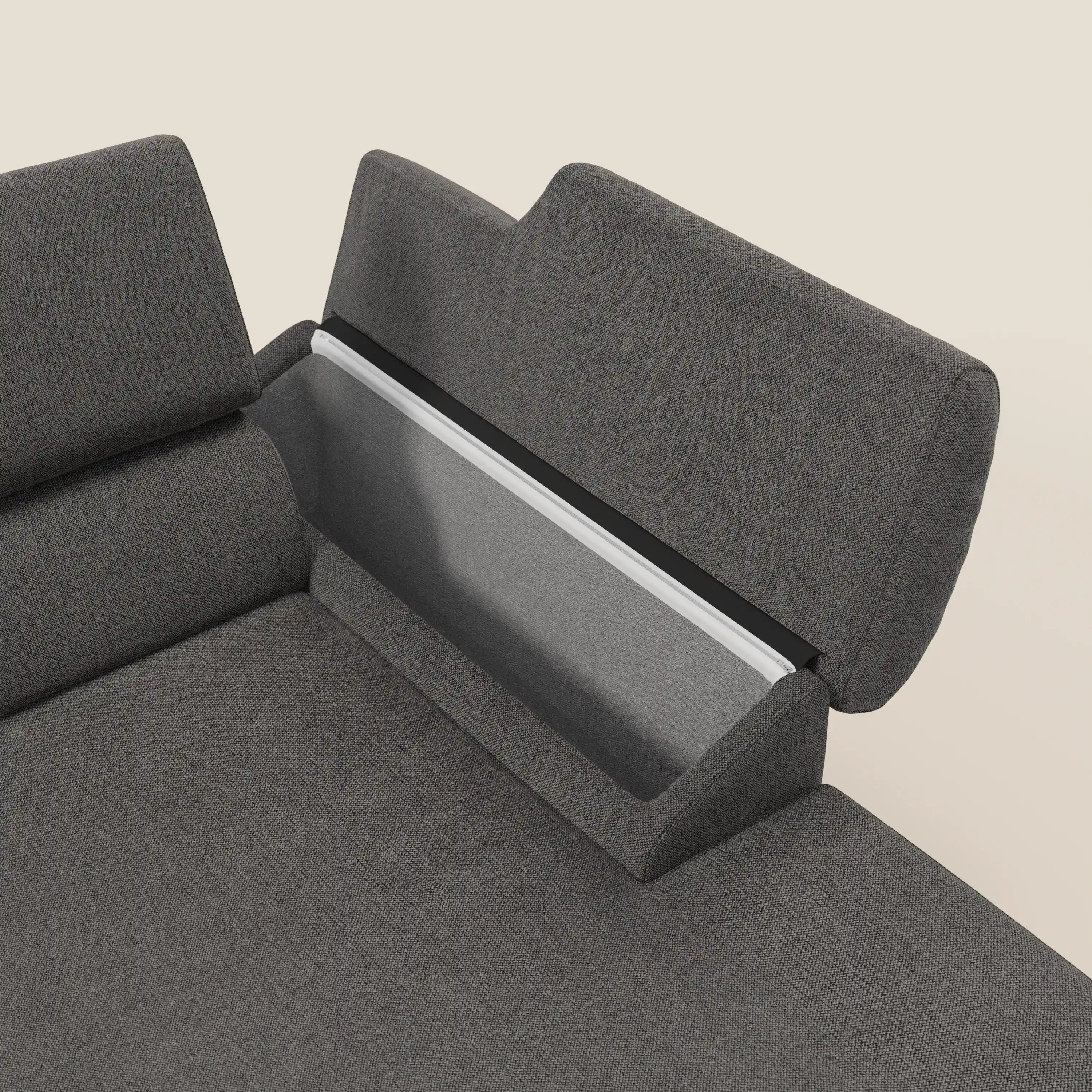 Primo piano del divano angolare Donatello di Divani.Store in tessuto smacchiabile T23 antracite, con sedute scorrevoli, braccioli contenitori e poggiatesta regolabili, su uno sfondo chiaro.