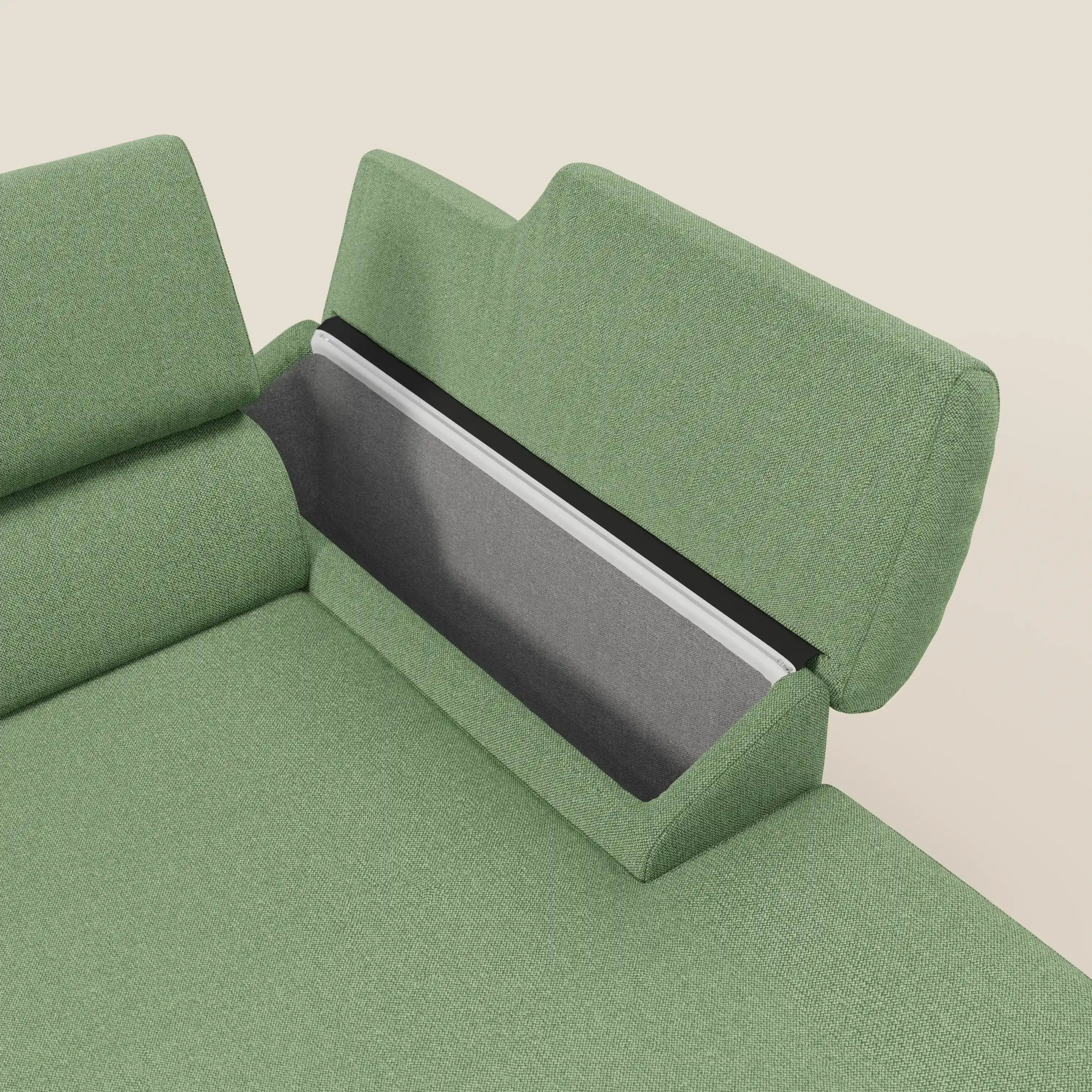 Il Divano angolare Donatello di Divani.Store in T23 menta è caratterizzato da sedute scorrevoli, poggiatesta regolabili, braccioli e un vano nascosto con fodera nera e grigia, su sfondo beige tinta unita per un comfort evoluto.