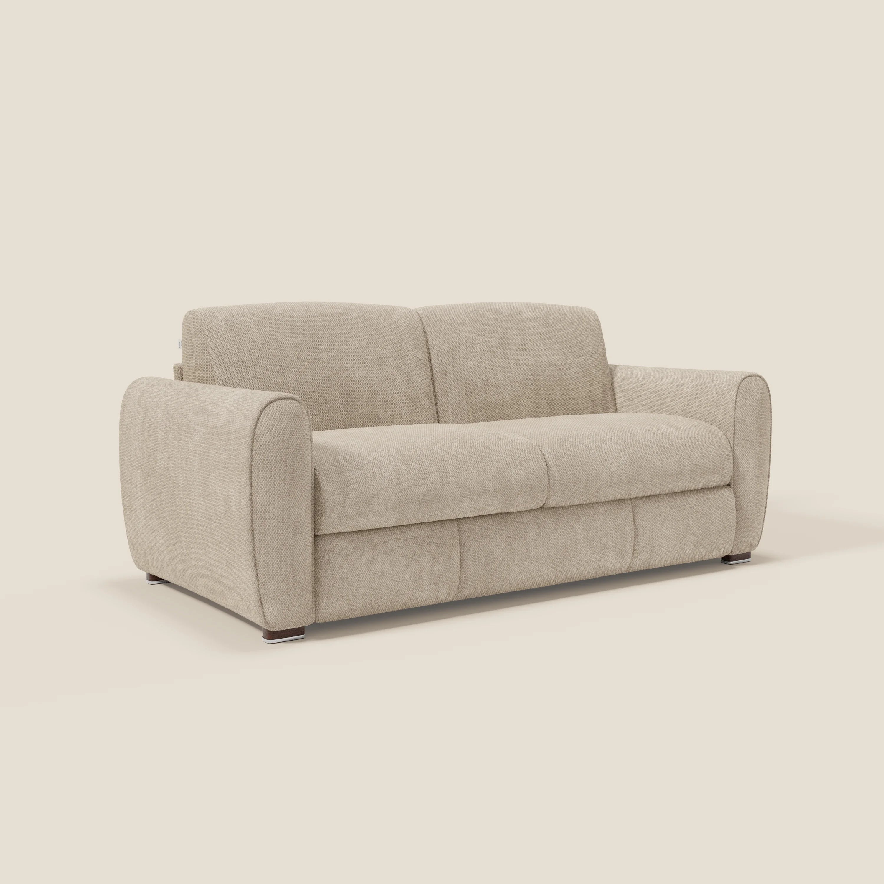 Un moderno divano in tessuto beige, con cuscini morbidi, ampi braccioli arrotondati e gambe basse e scure, su uno sfondo bianco sporco. Il design è minimalista e contemporaneo.