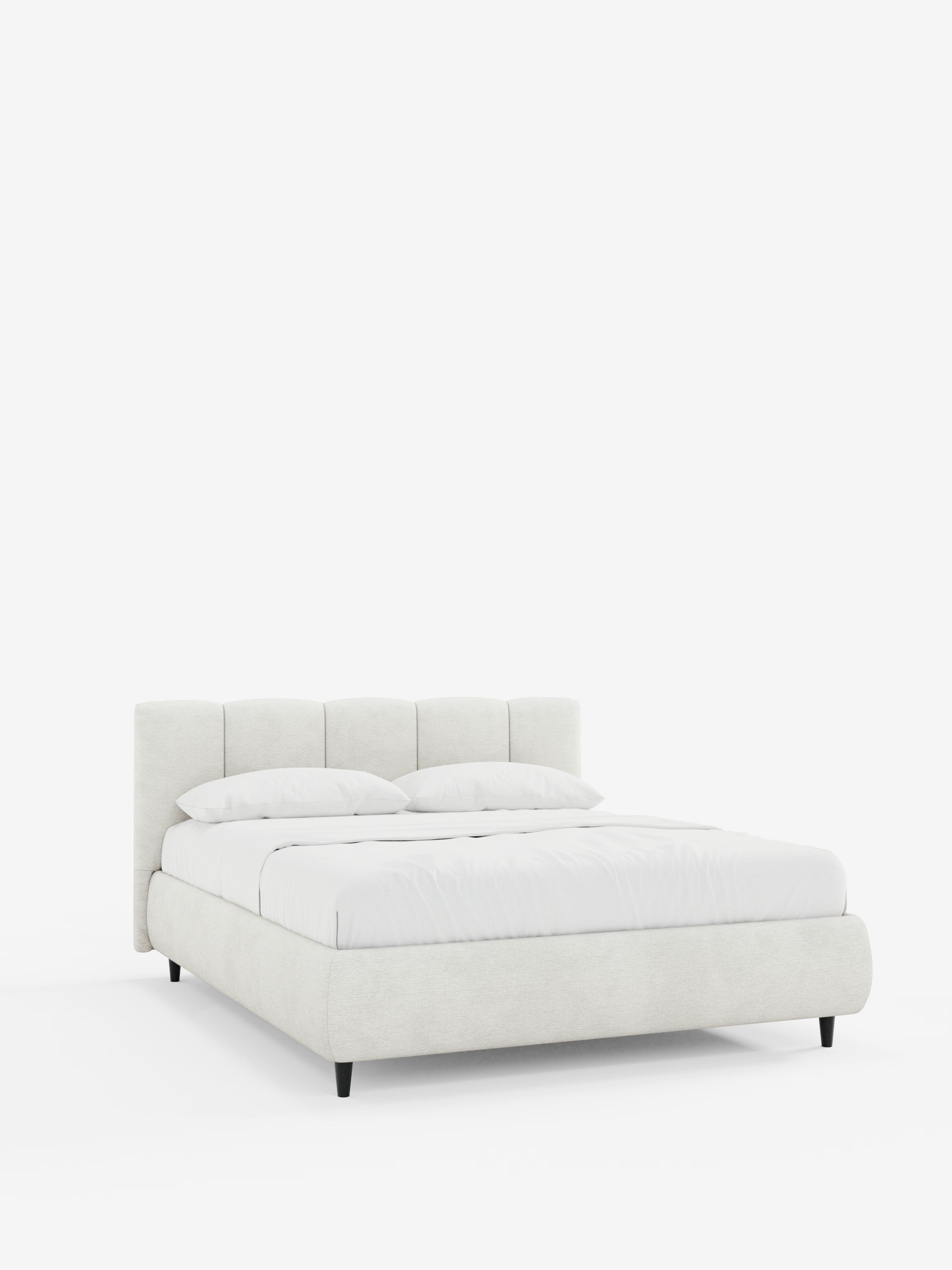 Un letto imbottito ARKAM in stile contemporaneo con contenitore e testiera a cuciture verticali di Letti.store, caratterizzato da una struttura in tessuto chiaro certificato Oeko-Tex® e da una testiera trapuntata con cuciture verticali. Il letto è abbinato a una biancheria da letto di un bianco brillante e a due cuscini, poggia su gambe corte nere ed è fotografato su uno sfondo bianco a tinta unita.