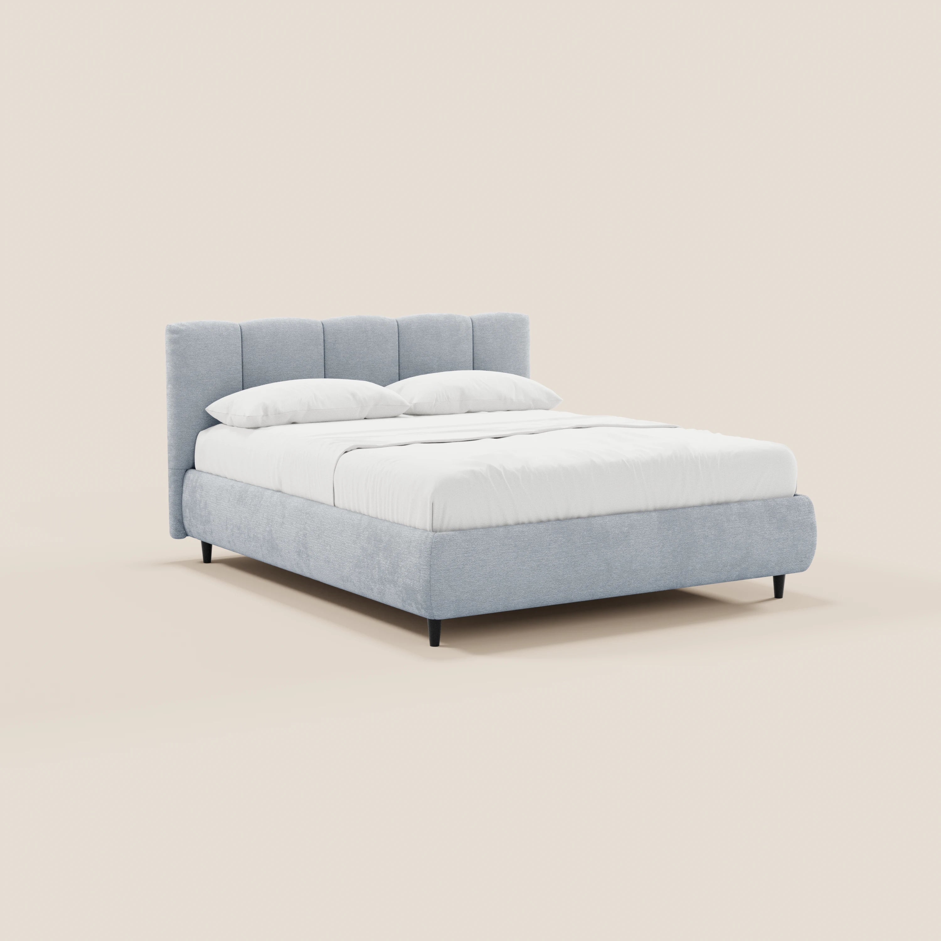 Il letto imbottito ARKAM di Letti.store, realizzato in tessuto Oeko-Tex®, presenta una testiera con lavorazione verticale di colore grigio chiaro e un vano contenitore, con biancheria da letto bianca e due cuscini su sfondo beige chiaro, per uno stile shabby chic contemporaneo.