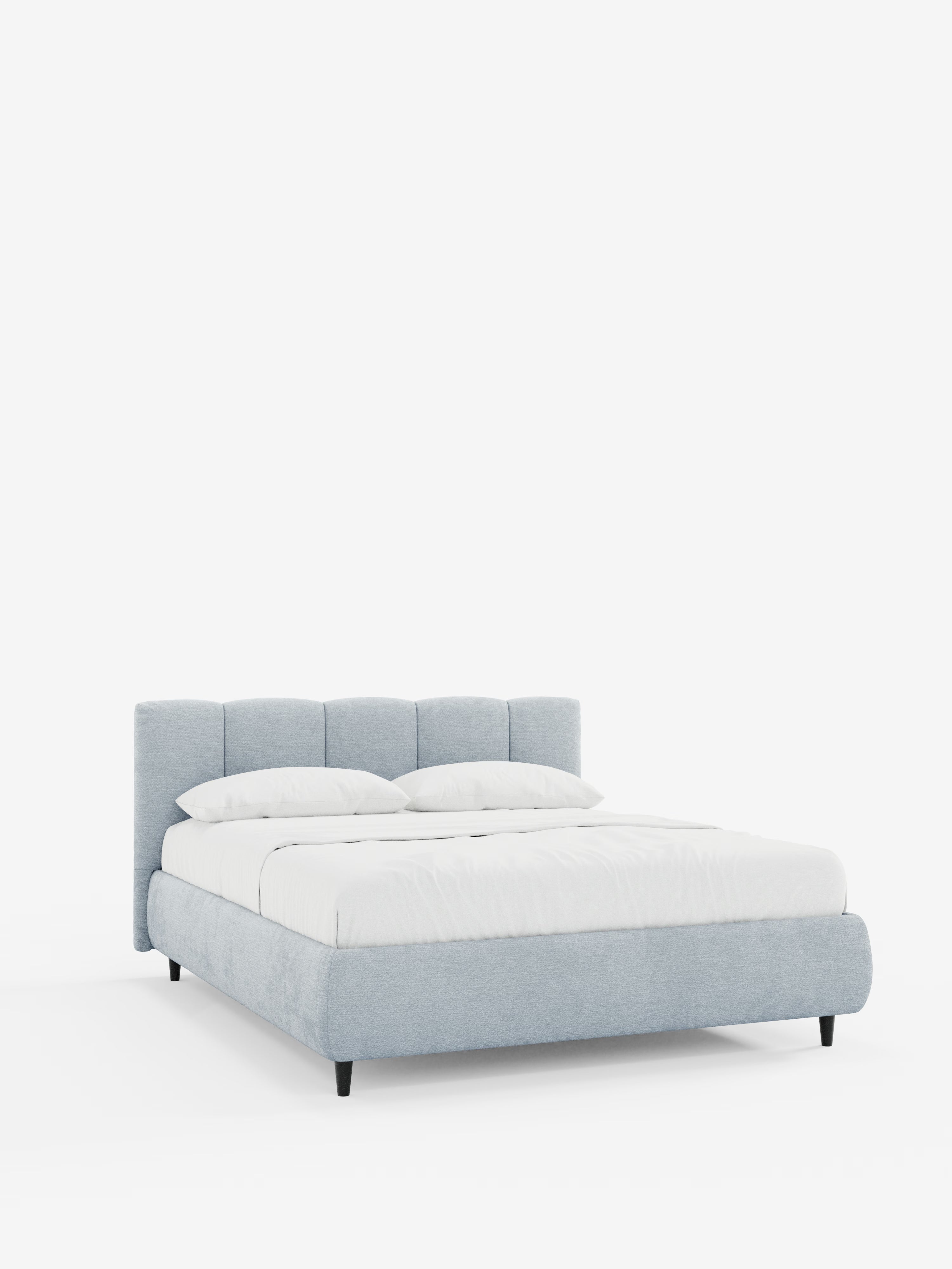 Il letto imbottito ARKAM con vano contenitore e testiera a cuciture verticali di Letti.store è un elegante letto a piattaforma di colore azzurro, caratterizzato da una testiera bassa, imbottita e con cuciture verticali, e da gambe corte nere. Il letto è abbinato a una biancheria da letto di un bianco brillante e a due cuscini su uno sfondo bianco a tinta unita, creando un look moderno ma allo stesso tempo shabby chic. Realizzato in tessuto certificato Oeko-Tex®, questo versatile complemento d’arredo con