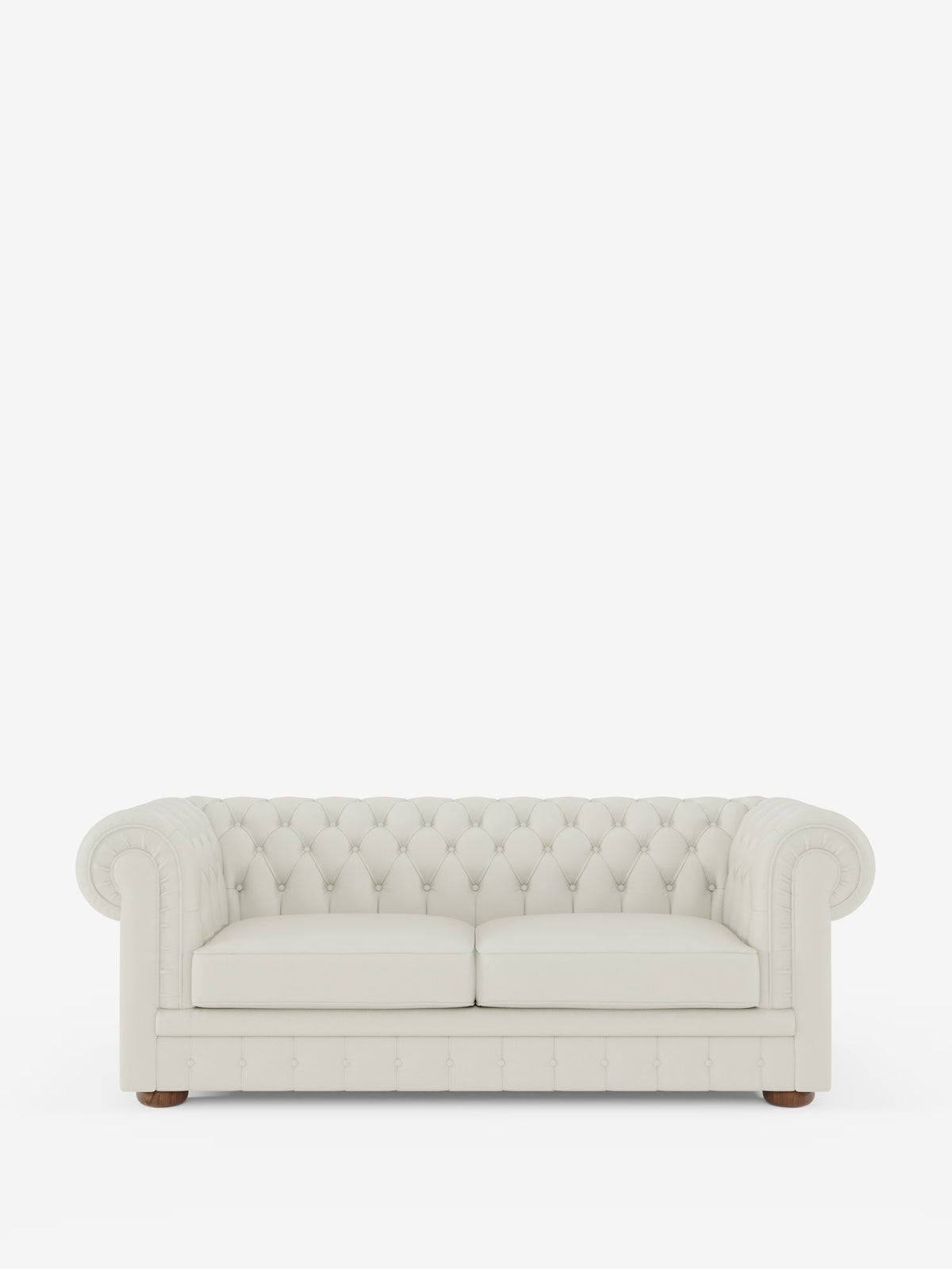 Un divano Chesterfield color crema in pelle trapuntata – Divano Chesterfield in vera pelle spessorata a 2 e 3 posti di Divani.Store, caratterizzato da braccioli arrotondati e due cuscini di seduta, poggia su piccoli piedini in legno su uno sfondo bianco a tinta unita, mettendo in risalto la raffinata maestria artigianale di un divano italiano fatto a mano.
