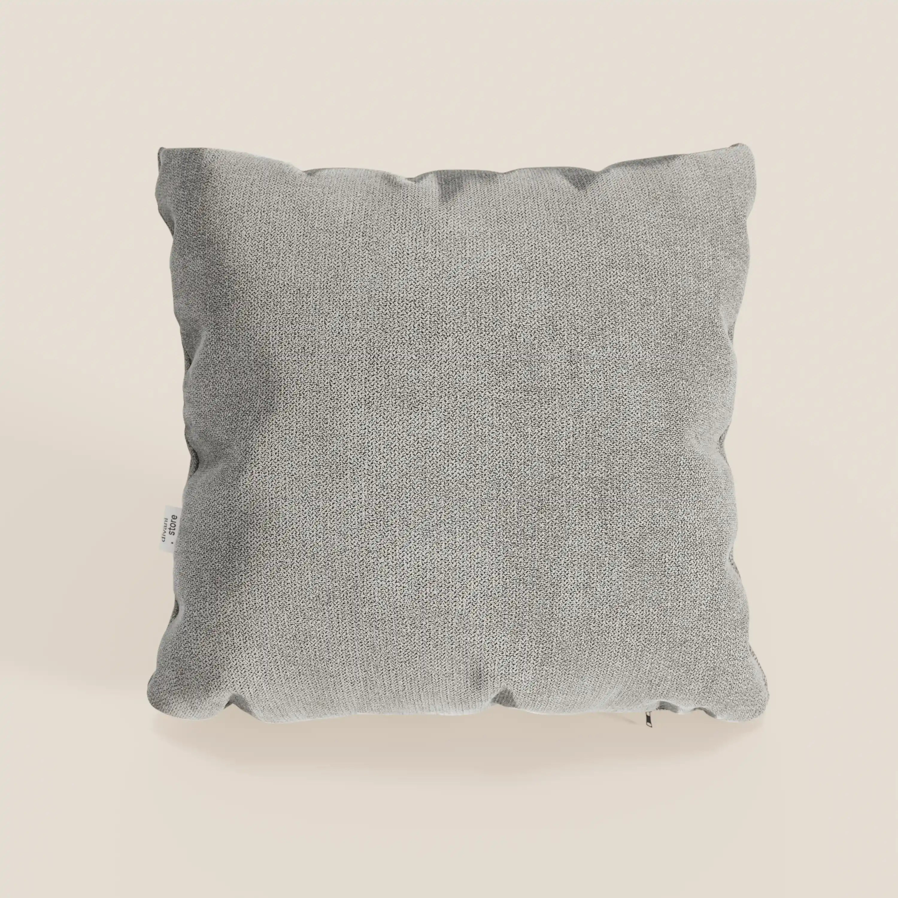 Il cuscino Destiny di Divani.Store, misura 45x45 cm in morbido tessuto impermeabile T02 beige, è presentato con un aspetto leggermente soffice e una piccola etichetta bianca sulla cucitura sinistra su uno sfondo bianco sporco.