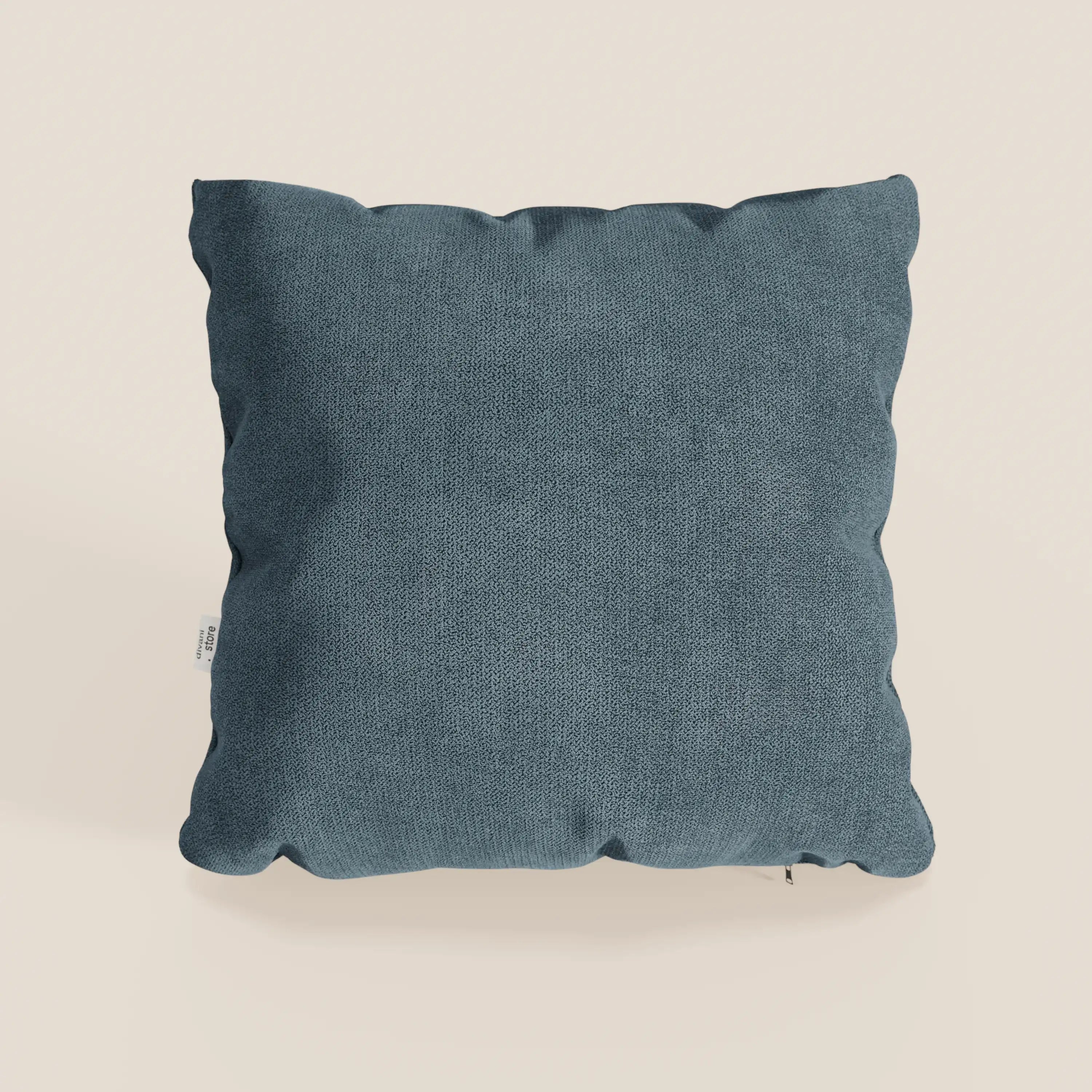 Il cuscino Destiny di Divani.Store, 45x45 cm, è presentato in T02 petrolio: un tessuto morbido e impermeabile di colore grigio-blu scuro. Appare felpato con sottili rughe e presenta una piccola etichetta bianca sul bordo sinistro su uno sfondo bianco sporco.
