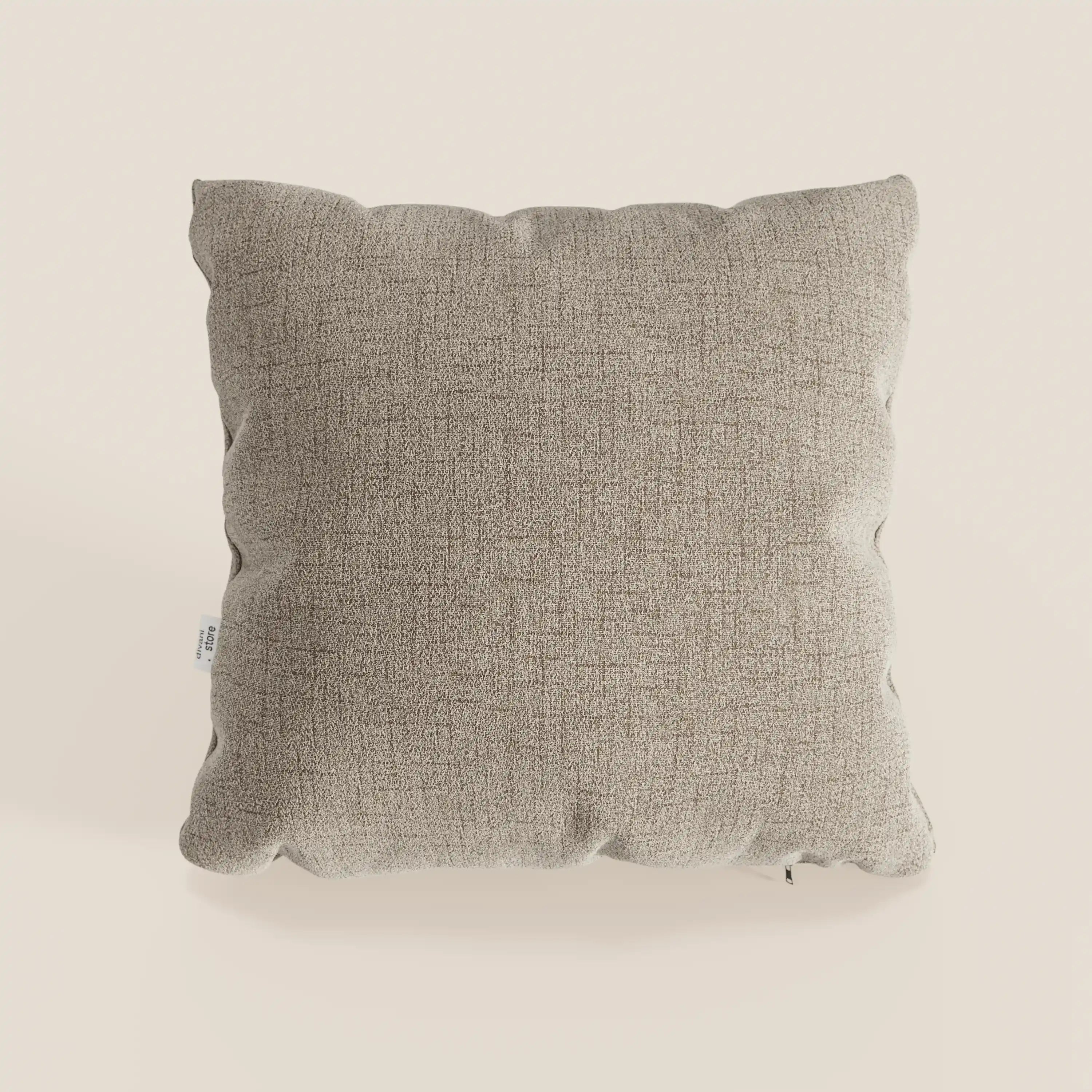 Il cuscino Felis cuscini di Divani.Store è un cuscino quadrato e morbido di colore beige in tessuto impermeabile T03, con una texture sottile, bordi delicatamente arrotondati e una targhetta sul lato sinistro, su uno sfondo crema chiaro. Disponibile in vari colori.