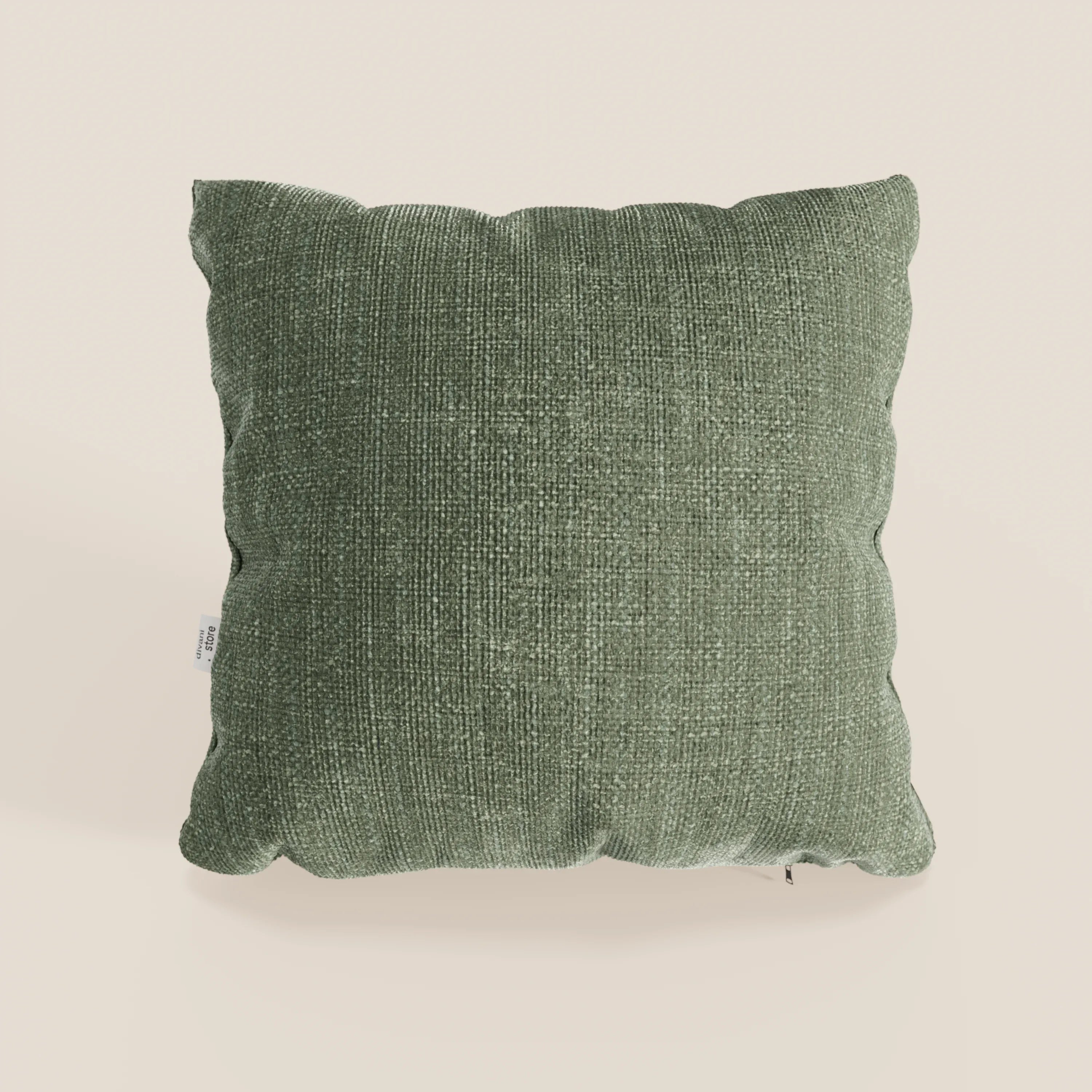 Il cuscino Lyon di Divani.Store, presentato nel colore verde testurizzato T06 (45x45 cm), è realizzato in morbido tessuto impermeabile con angoli arrotondati e una targhetta bianca sul lato sinistro, su uno sfondo beige chiaro.