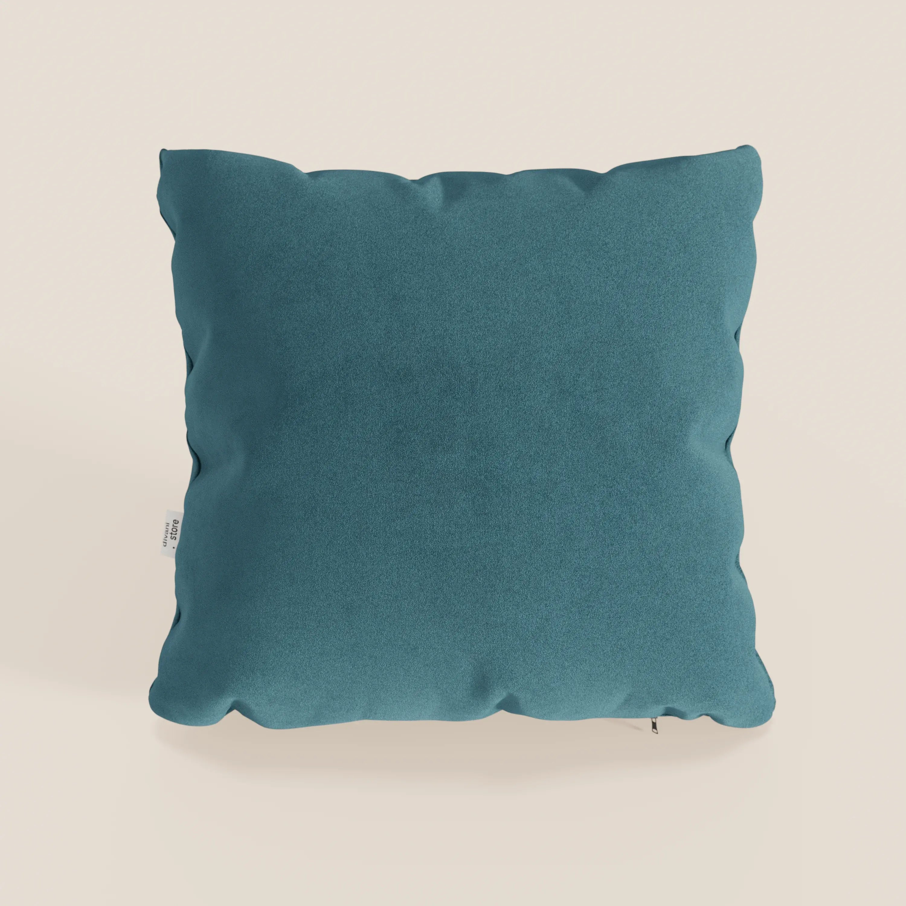 Il cuscino Jazz di Divani.Store, presentato nel colore T11 petrolio, è un cuscino decorativo quadrato in microfibra tecnica smacchiabile con una texture sottile, un aspetto morbido e felpato e una piccola etichetta bianca a sinistra su uno sfondo beige chiaro.