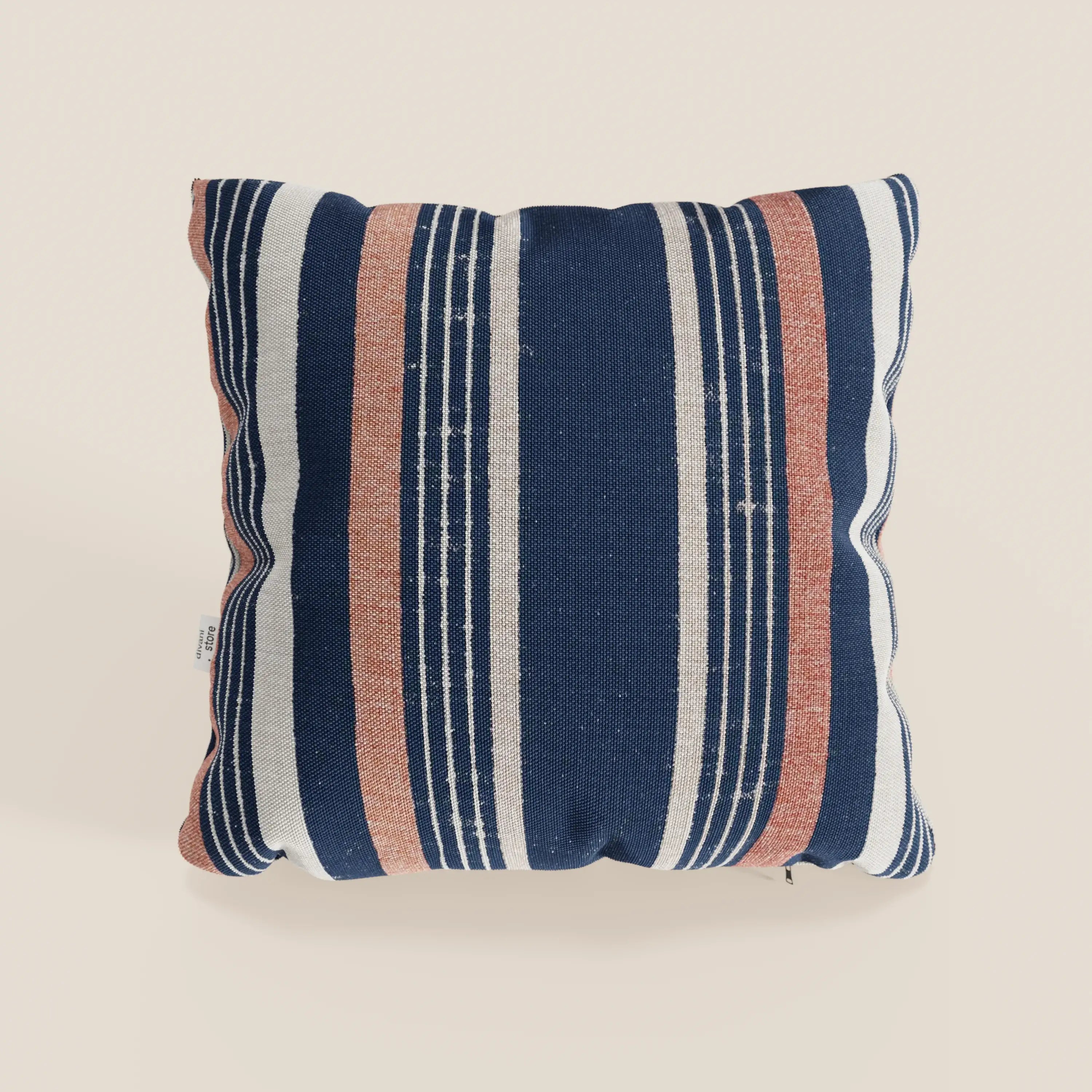 Il cuscino Line 45x45 cm di Divani.Store è caratterizzato da una fantasia rigata in tessuto impermeabile, con righe alternate blu navy, bianche e arancione ruggine. Disponibile in due varianti di colore arancione, su sfondo chiaro.