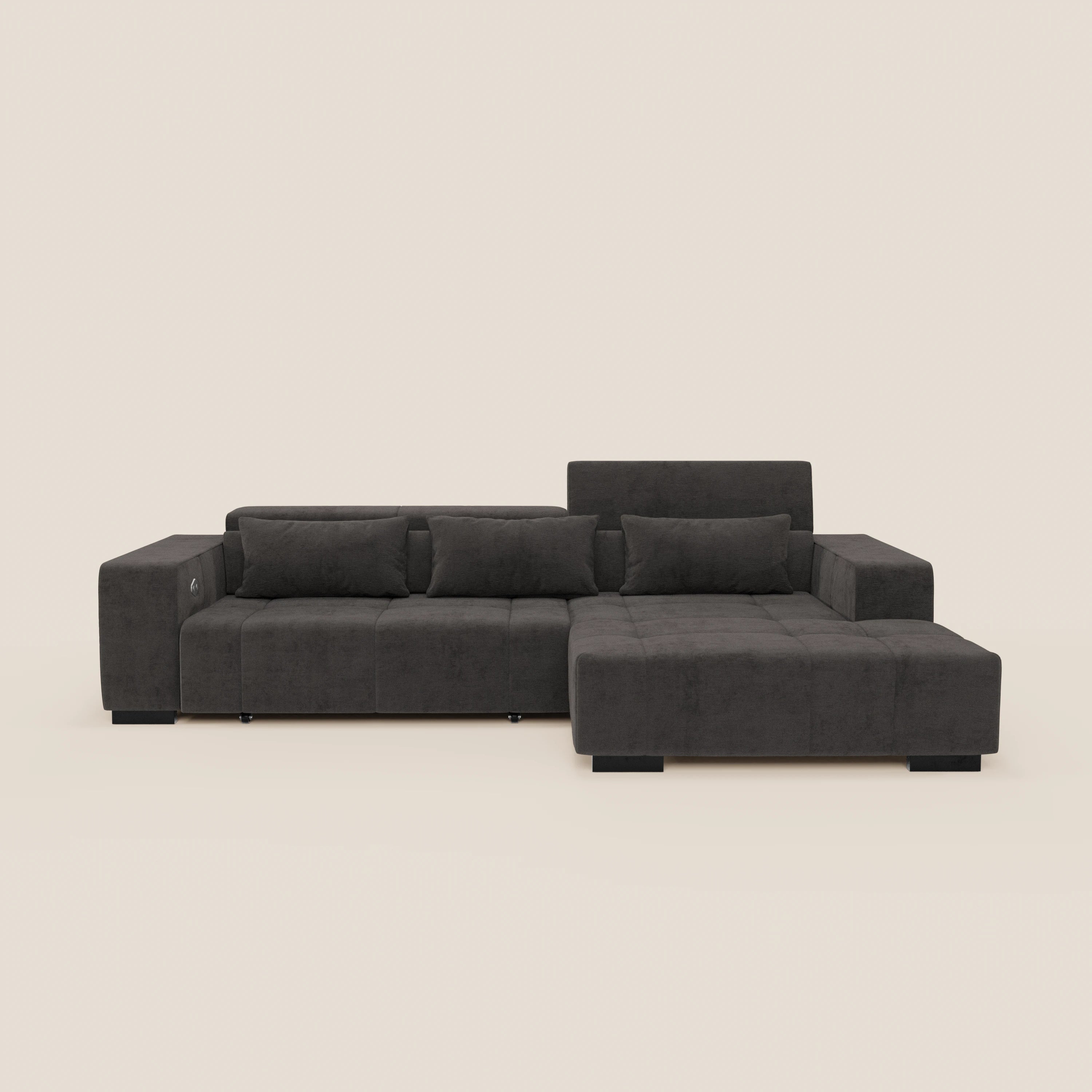 Il Monarch Divano angolare con penisola e Relax Elettrico di Divani.Store è caratterizzato da chaise longue destra, braccioli larghi, schienali bassi con poggiatesta reclinabile, tre cuscini di schienale, due cuscini rettangolari in tessuto T31 grigio scuro su gambe corte nere su sfondo bianco sporco.