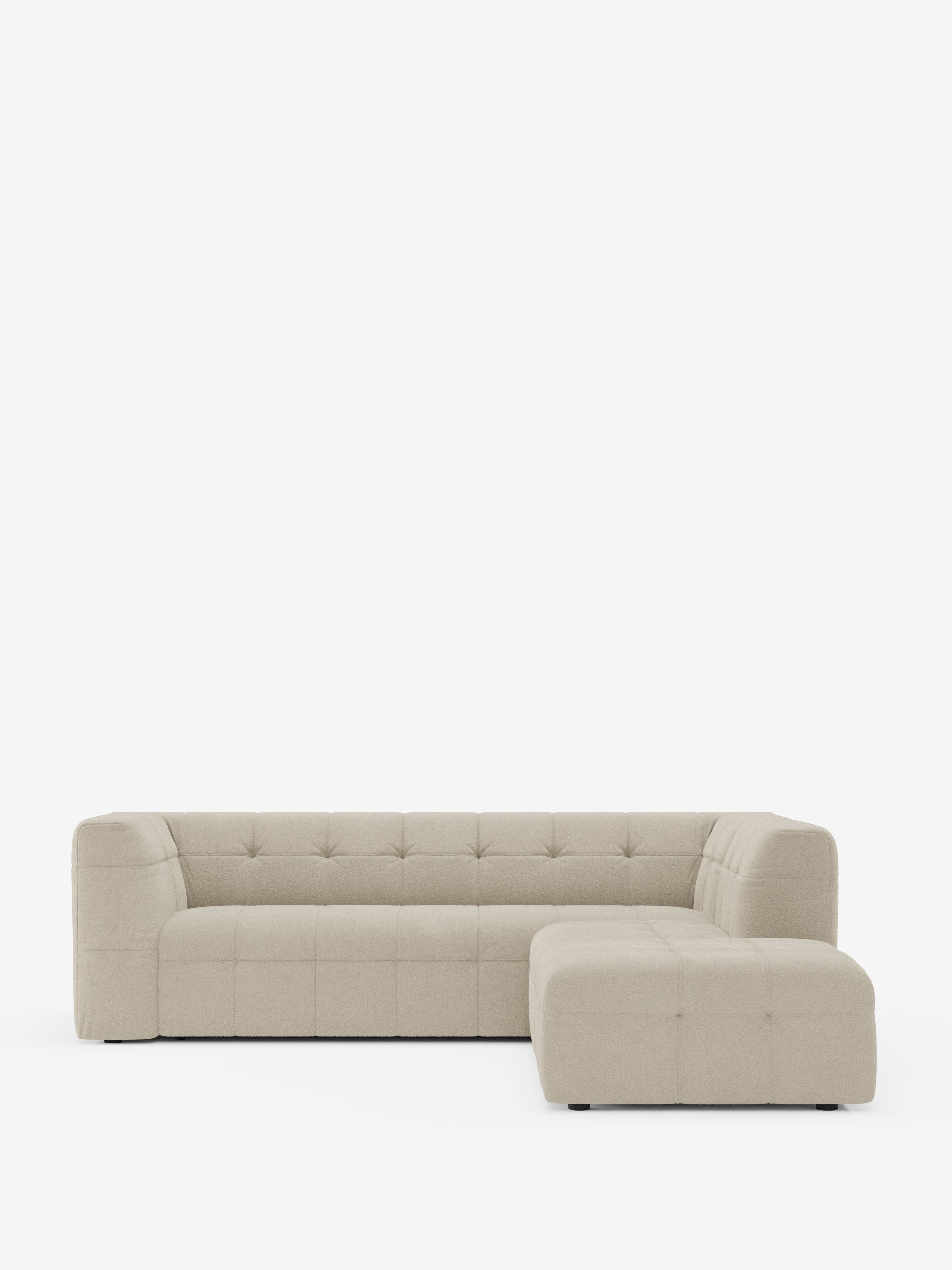 Su uno sfondo bianco a tinta unita, il divano angolare componibile e modulare Mosaic in bouclé di Divani.Store si presenta con una silhouette a L di colore beige, cuscini capitonné e braccioli e schienale bassi e squadrati. Questo divano moderno vanta linee pulite, un design minimalista senza gambe a vista ed è rivestito in tessuto T21 antimacchia, perfetto per un soggiorno moderno.