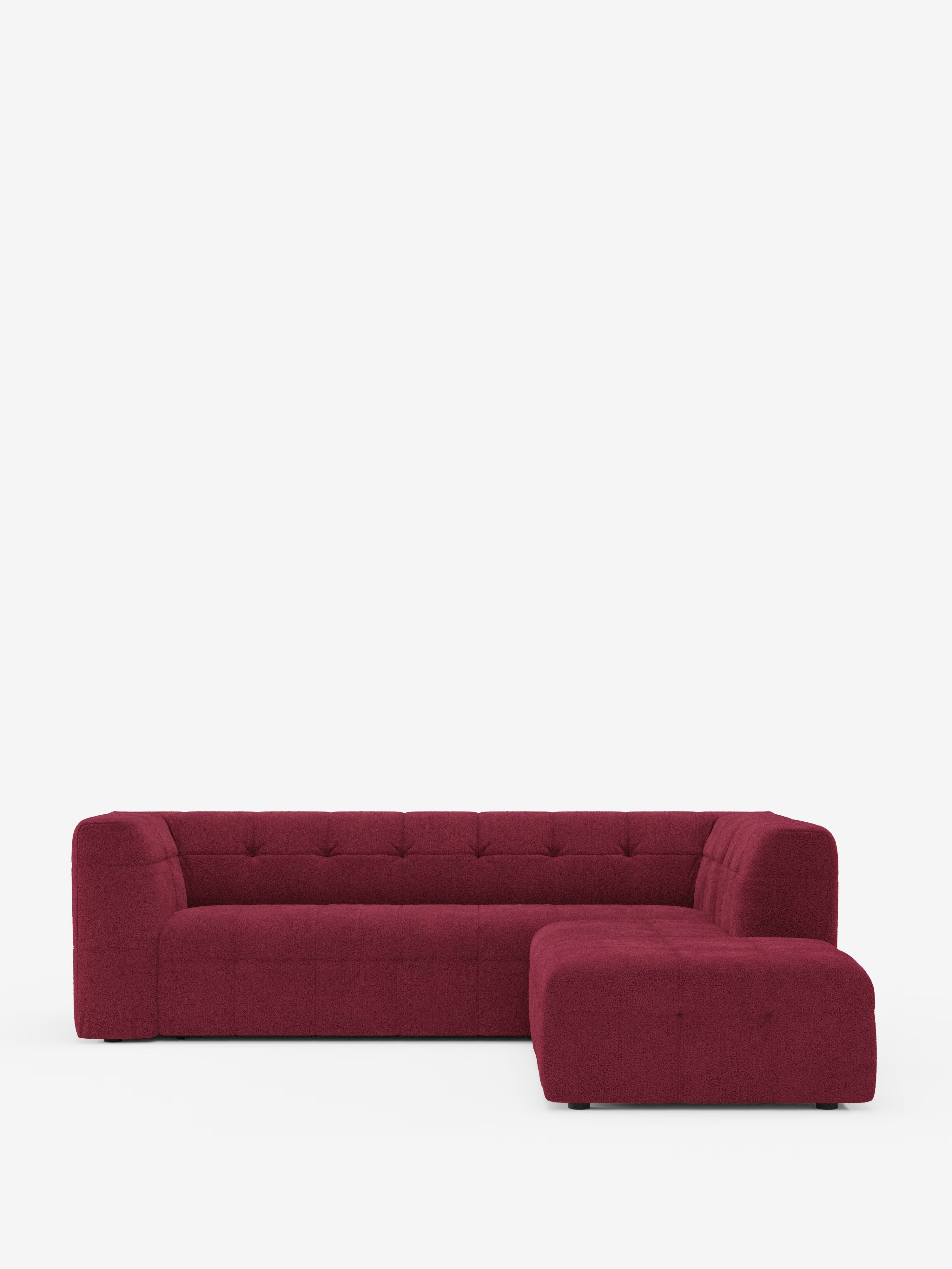 Il divano angolare componibile e modulare Mosaic in bouclé di Divani.Store presenta un moderno design a forma di L, rivestito in tessuto T21 rosso intenso e resistente alle macchie, con un’elegante trapuntatura capitonné a quadrati sulla seduta e sullo schienale. Ideale per un soggiorno moderno, questo divano presenta braccioli e schienale bassi e arrotondati, poggianti su brevi piedini neri che risaltano su uno sfondo bianco a tinta unita.