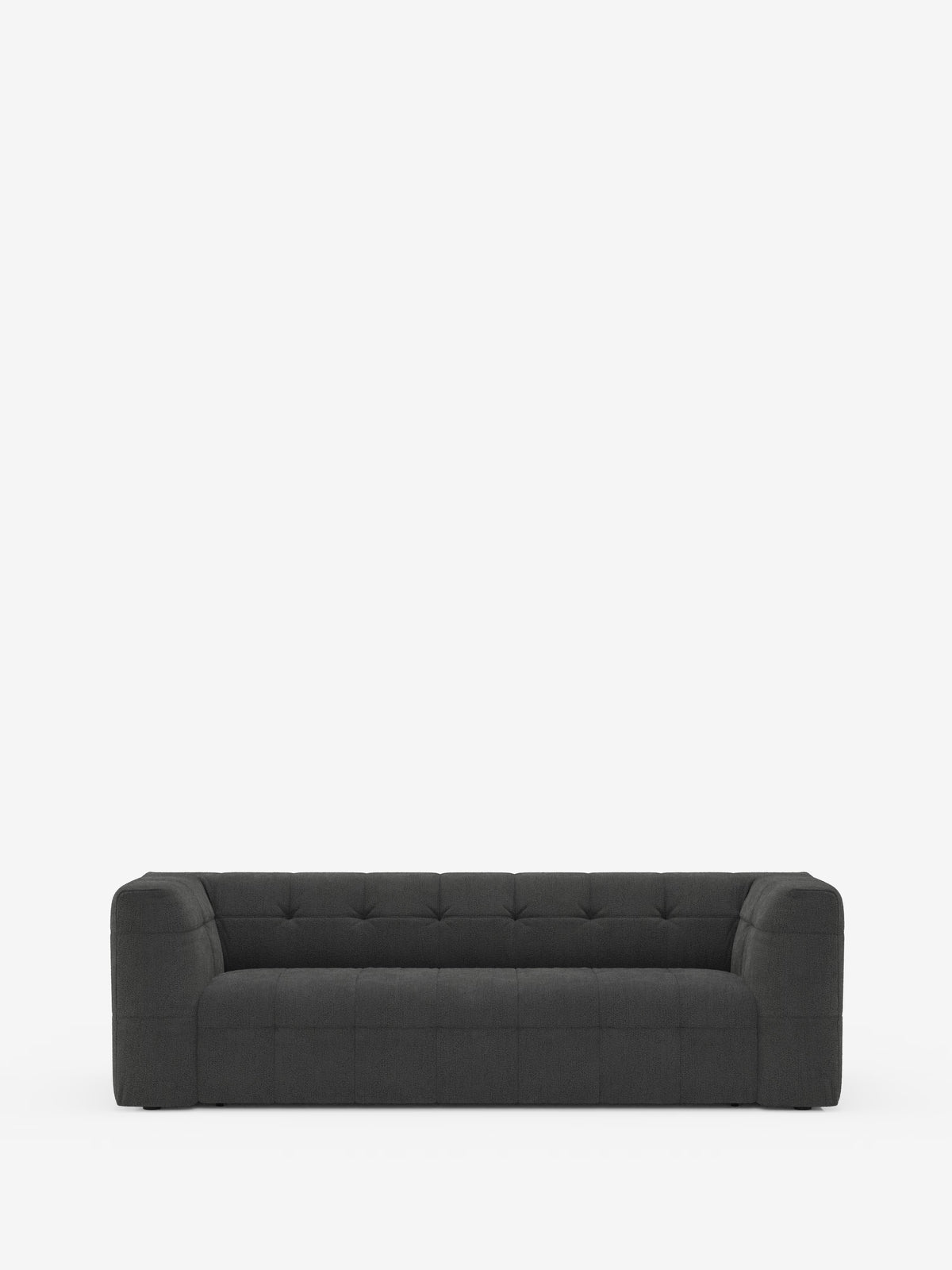 Un moderno divano modulare Mosaic Divano a 3 e 4 posti, di colore grigio scuro, realizzato in bouclé da Divani.Store, caratterizzato da un design capitonné con braccioli squadrati e schienale basso, è posizionato al centro su uno sfondo bianco a tinta unita. Il divano, morbido e trapuntato, presenta cuciture a vista e offre ampio spazio per tre persone.