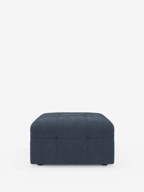Un pouf quadrato Mosaic di colore blu scuro, realizzato in bouclé da Divani.Store, delle dimensioni di 96x77 cm, spicca su uno sfondo bianco. Rivestito in morbido tessuto T21 antimacchia con un motivo capitonné (imbottito) che forma un elegante motivo a griglia su tutta la superficie, questo pouf di produzione italiana presenta piedini corti quasi invisibili che ne esaltano l'estetica slanciata.