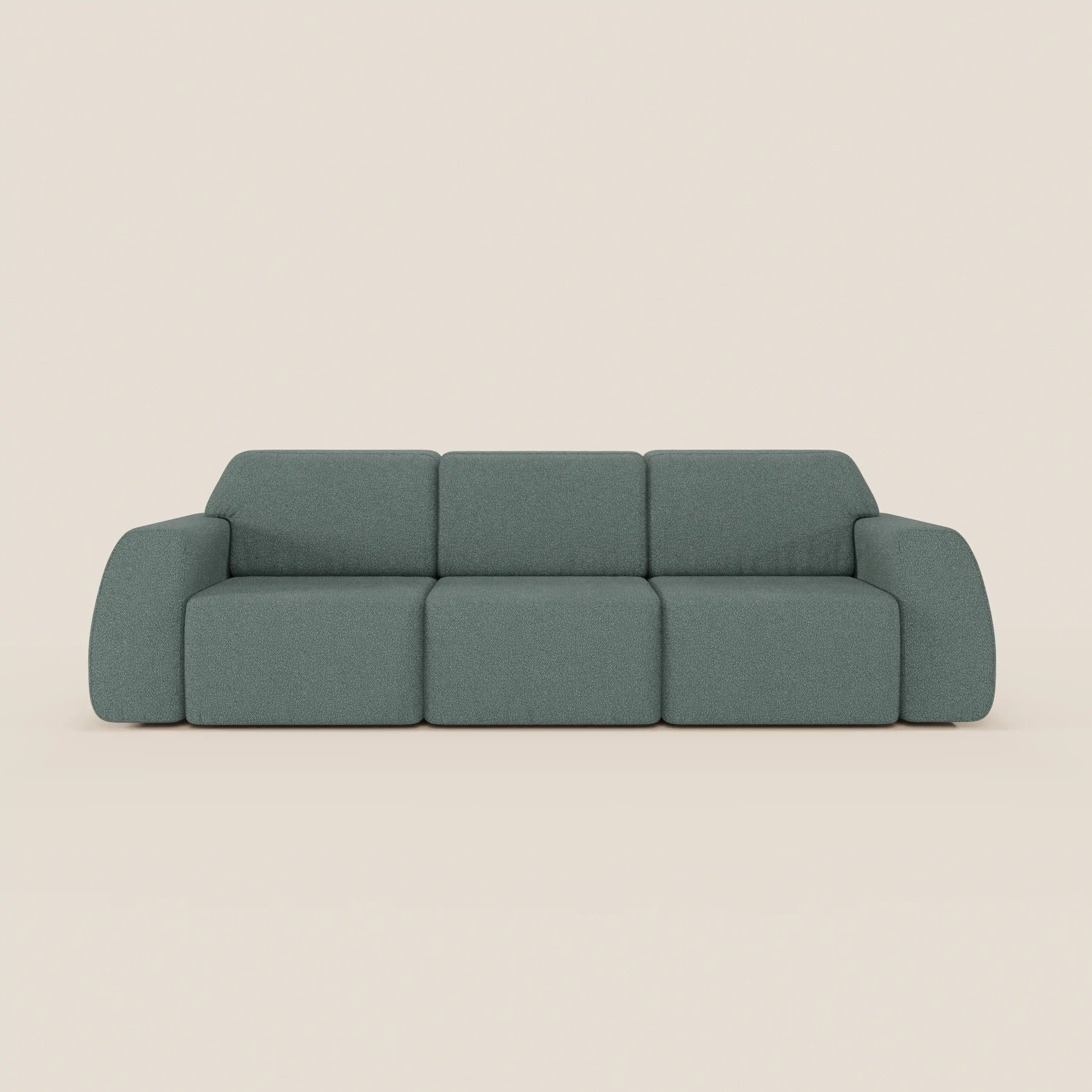 Divano Orbit con 3 sedute scorrevoli e allungabili in tessuto effetto cotone smacchiabile T33 di Divani.Store, moderno e minimal, rivestito in verde tenue, con braccioli e schienali ampi dalle forme morbide, su sfondo beige chiaro.