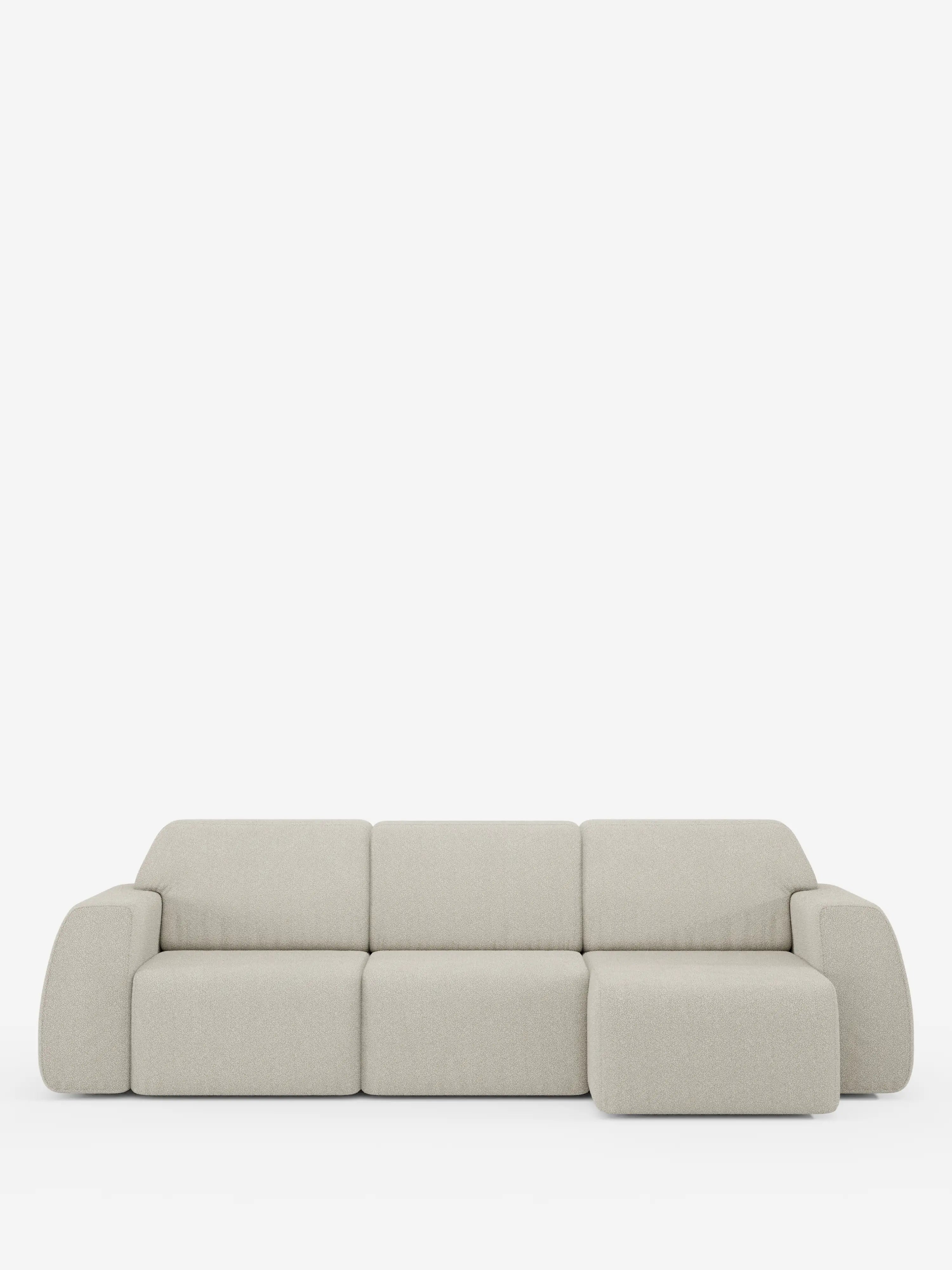 Un divano angolare contemporaneo Orbit con penisola reversibile di Divani.Store, rivestito in tessuto T33 effetto cotone beige chiaro, resistente alle macchie. È dotato di tre sedute principali estensibili, una chaise longue integrata che può essere posizionata su entrambi i lati, braccioli arrotondati e un morbido rivestimento in tessuto felpato, il tutto presentato su uno sfondo bianco a tinta unita.