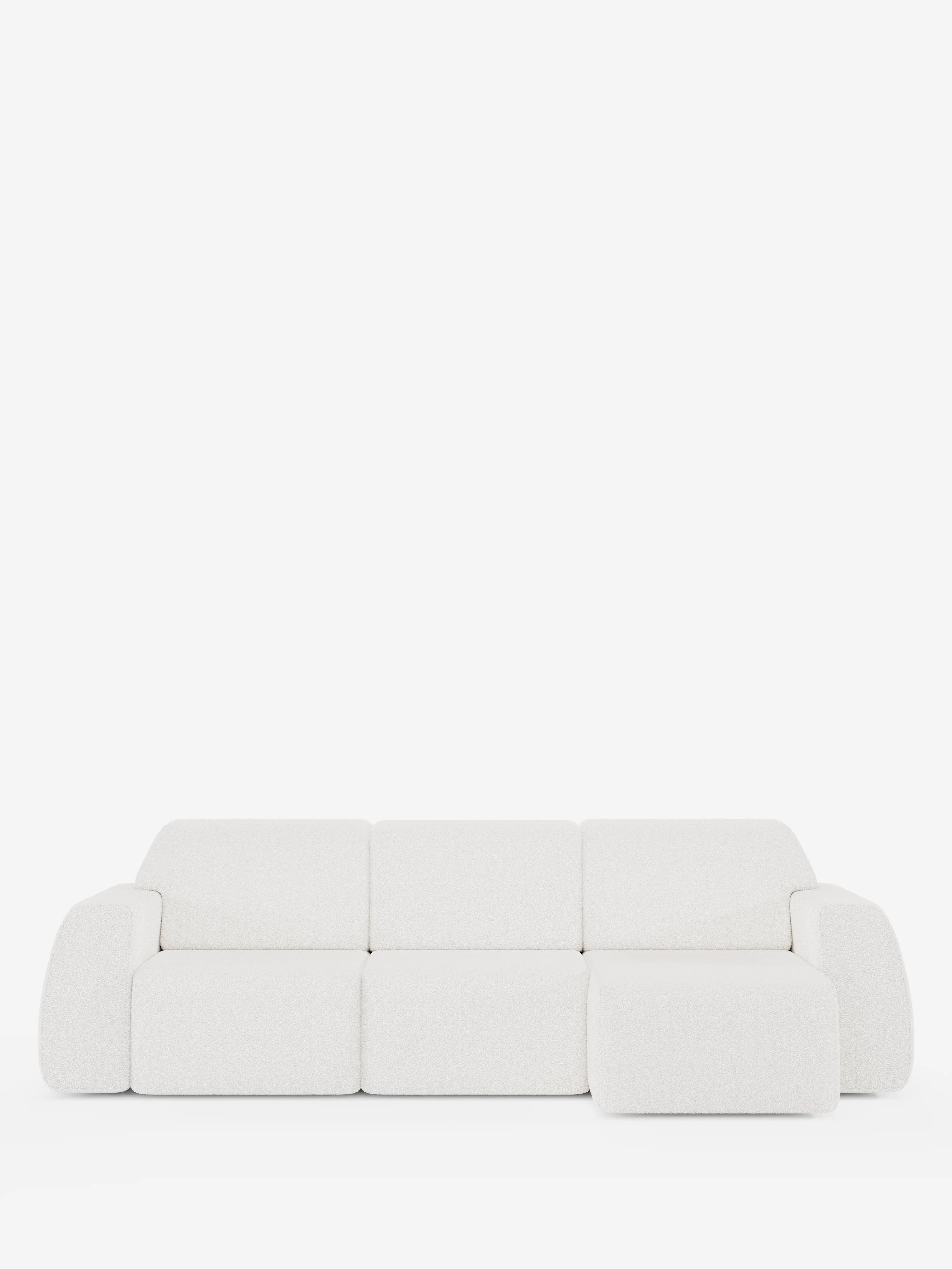 Un divano angolare Orbit contemporaneo, bianco, con penisola reversibile e tutte le sedute allungabili, rivestito in tessuto smacchiabile effetto cotone T33 di Divani.Store, caratterizzato da un design minimalista con bordi arrotondati e una chaise longue integrata sul lato destro, è presentato su uno sfondo bianco a tinta unita. Il rivestimento antimacchia effetto cotone appare morbido e soffice.